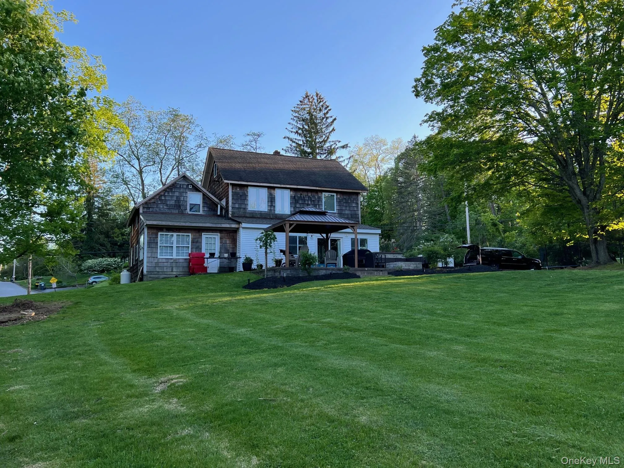 View of front of property with a front lawn and view of scattered trees View of front of property with a front lawn and view of scattered trees
