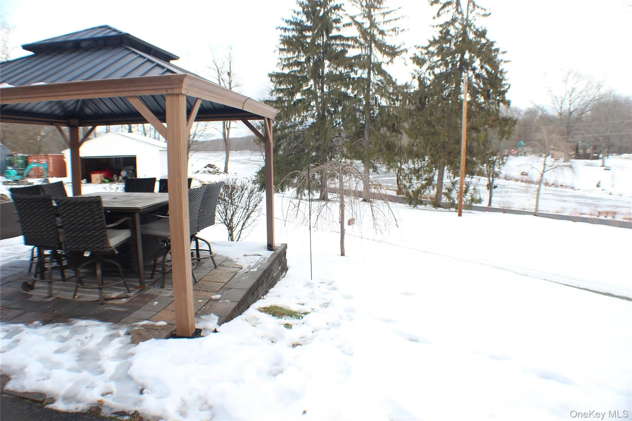 Yard covered in snow with a gazebo and outdoor dining area Yard covered in snow with a gazebo and outdoor dining area