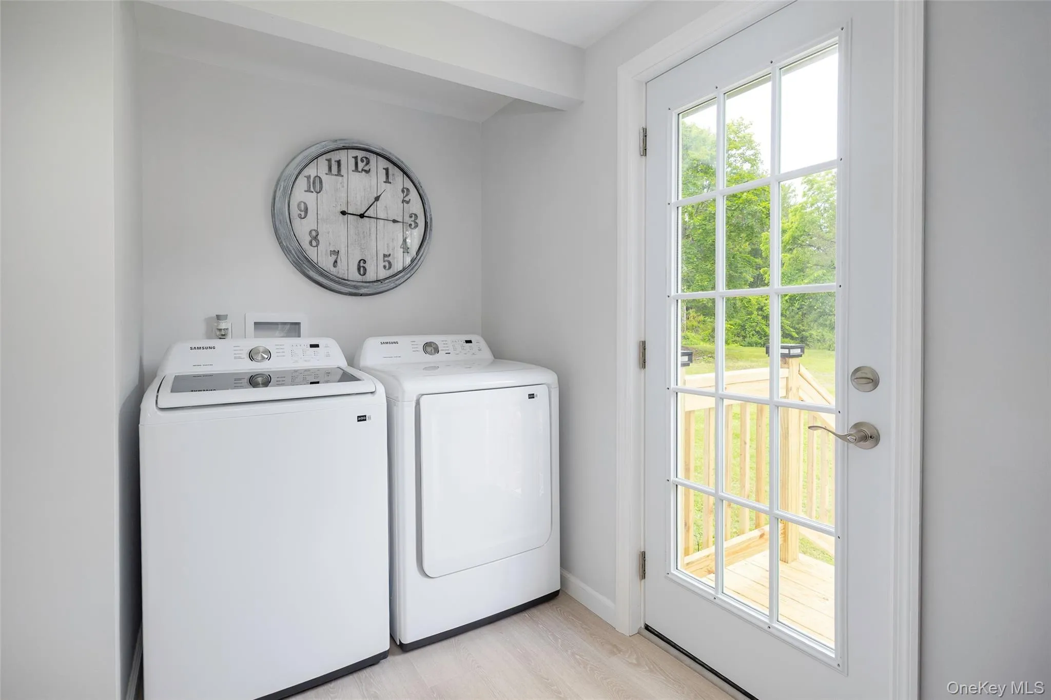 Washroom featuring washer and dryer and light wood-style floors Washroom featuring washer and dryer and light wood-style floors