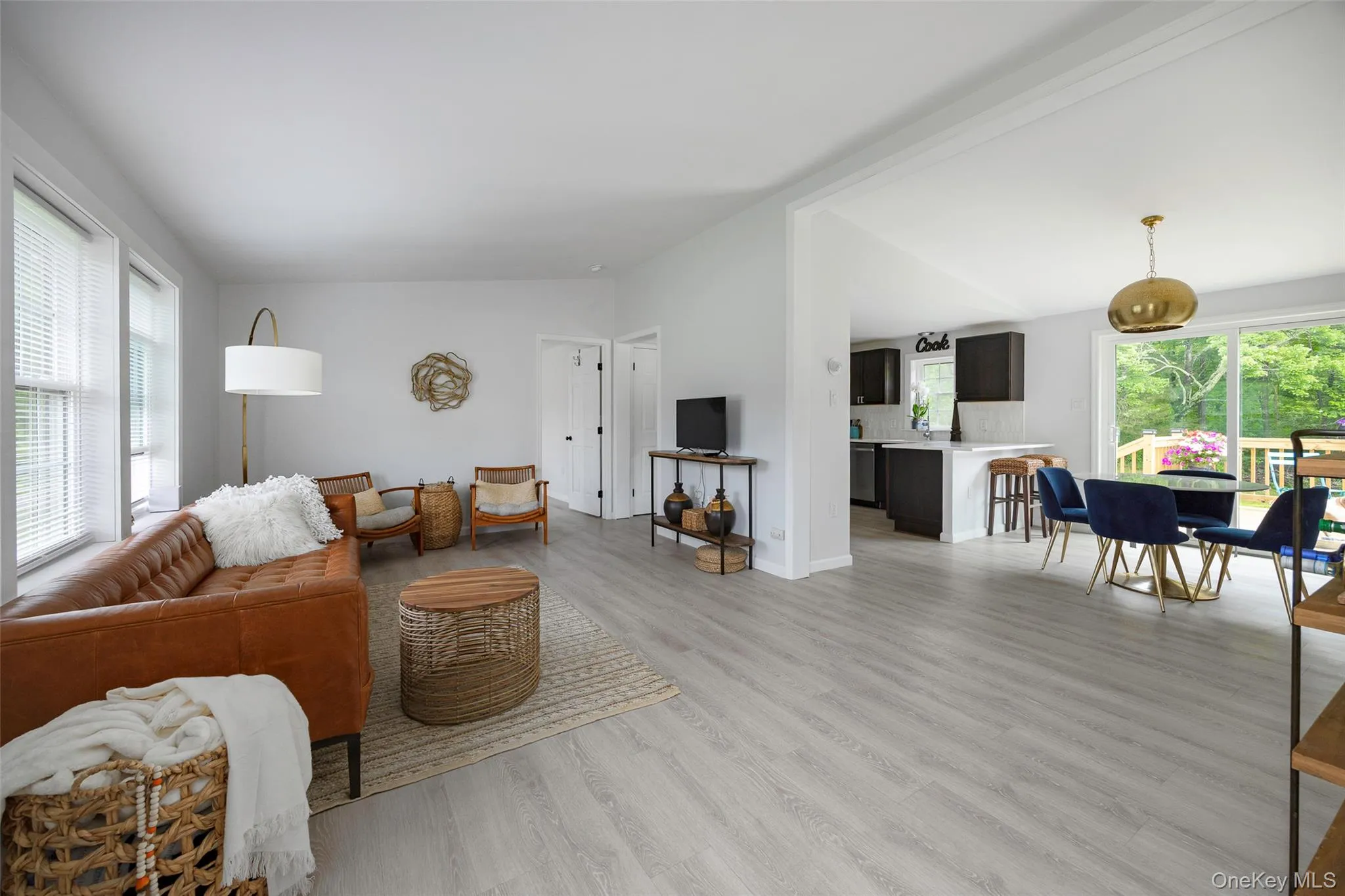 Living area featuring light wood-style floors and lofted ceiling Living area featuring light wood-style floors and lofted ceiling