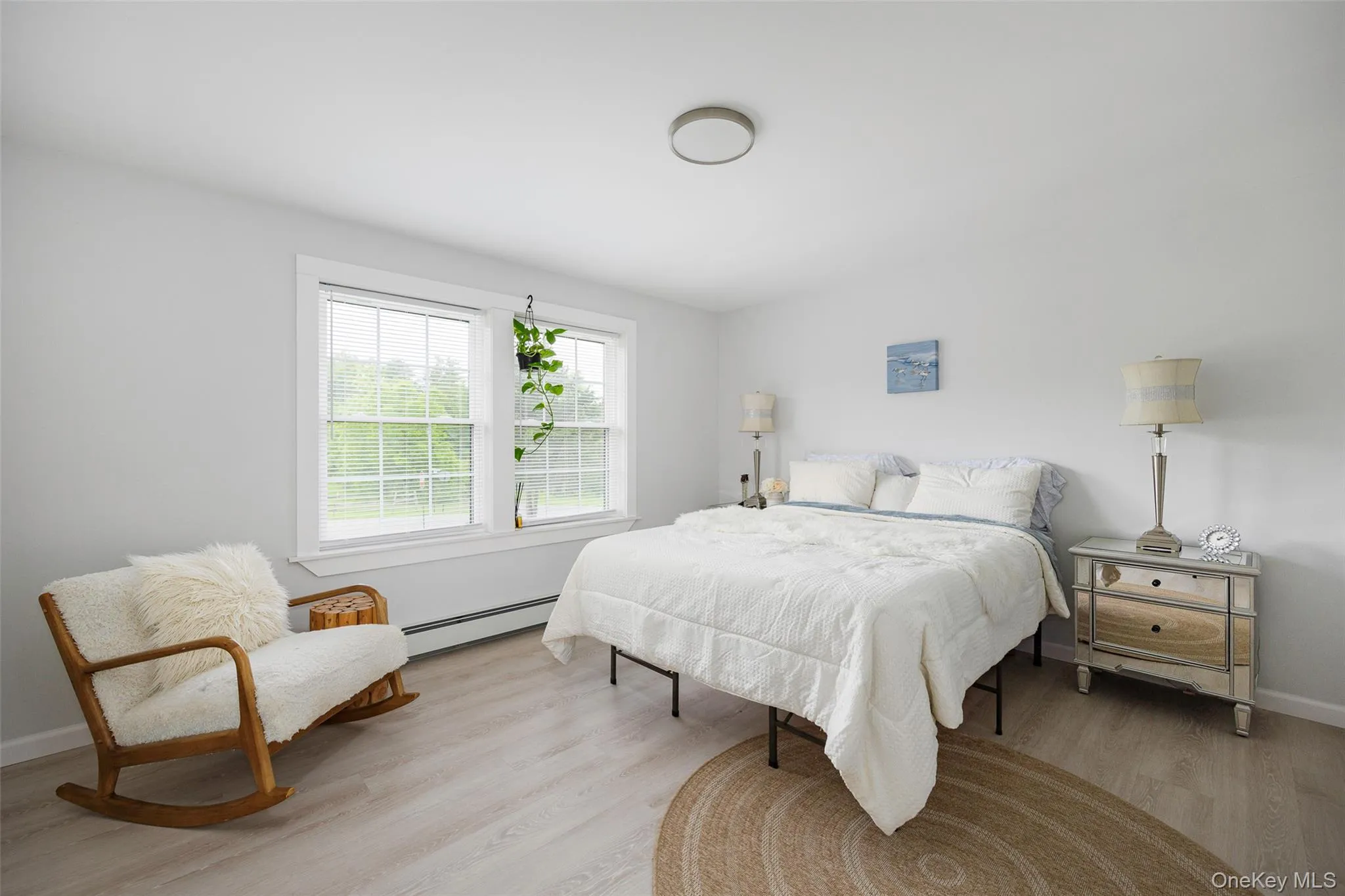 Bedroom with baseboard heating and light wood-type flooring Bedroom with baseboard heating and light wood-type flooring
