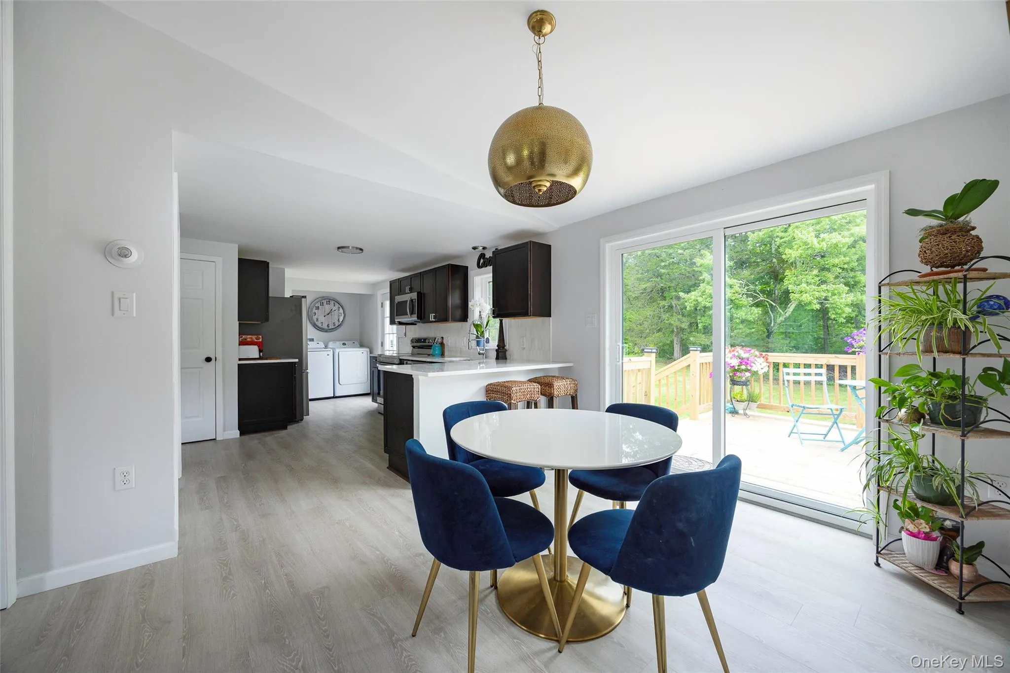Dining room featuring separate washer and dryer, light wood-style flooring, and vaulted ceiling Dining room featuring separate washer and dryer, light wood-style flooring, and vaulted ceiling