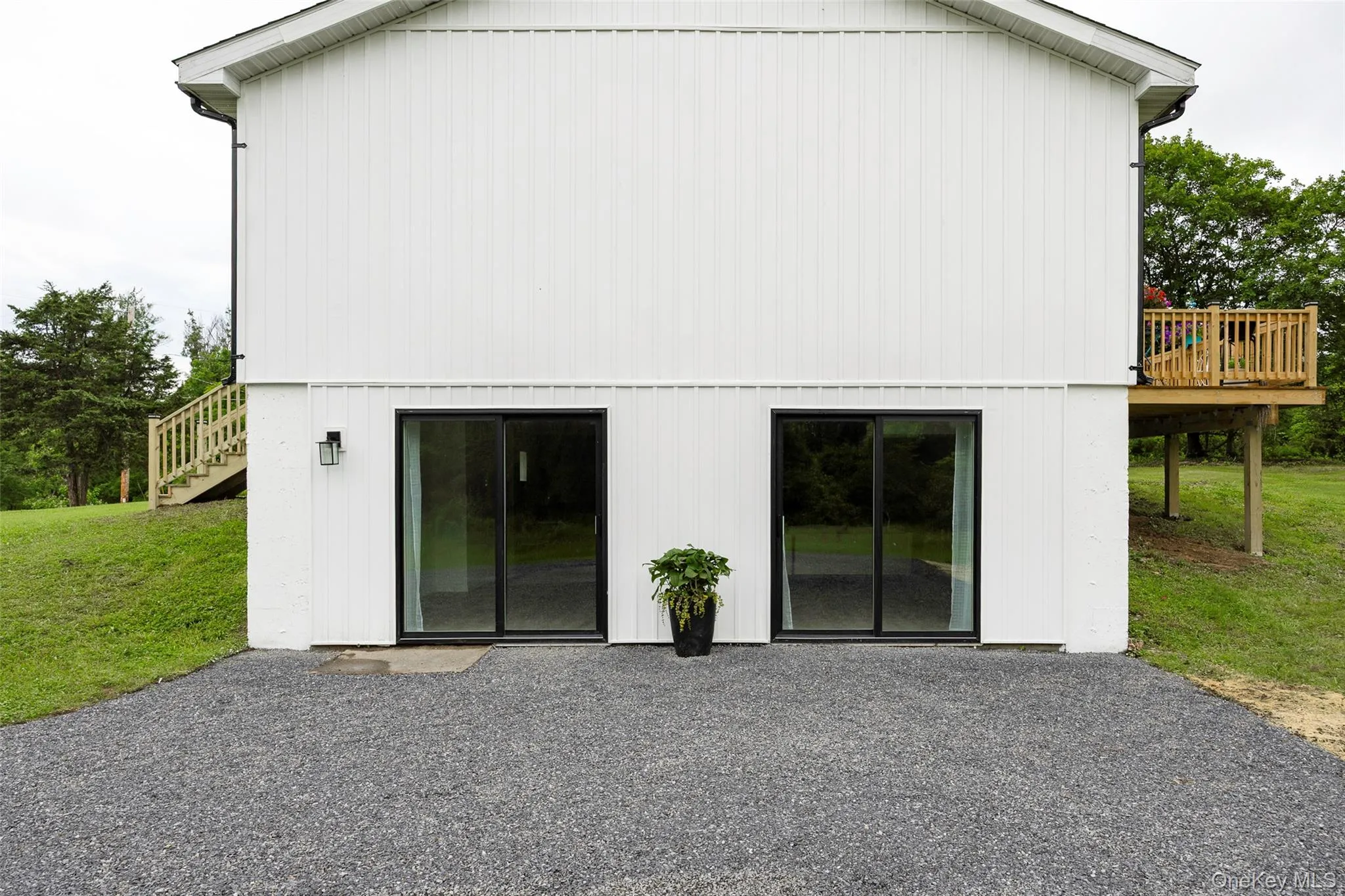 Back of house featuring a wooden deck, a yard, and a patio Back of house featuring a wooden deck, a yard, and a patio
