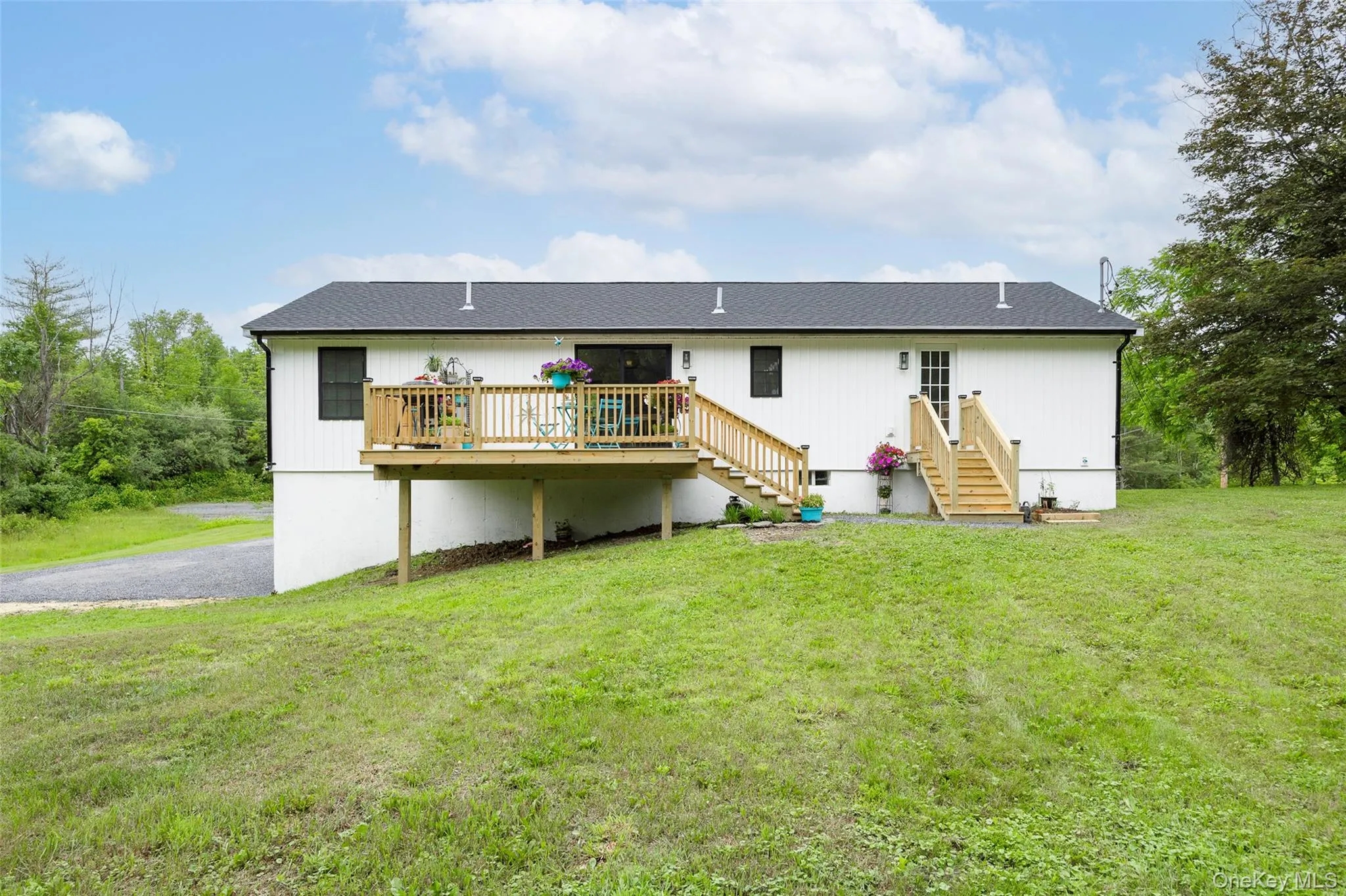 Back of property featuring a deck, a yard, and stairway Back of property featuring a deck, a yard, and stairway