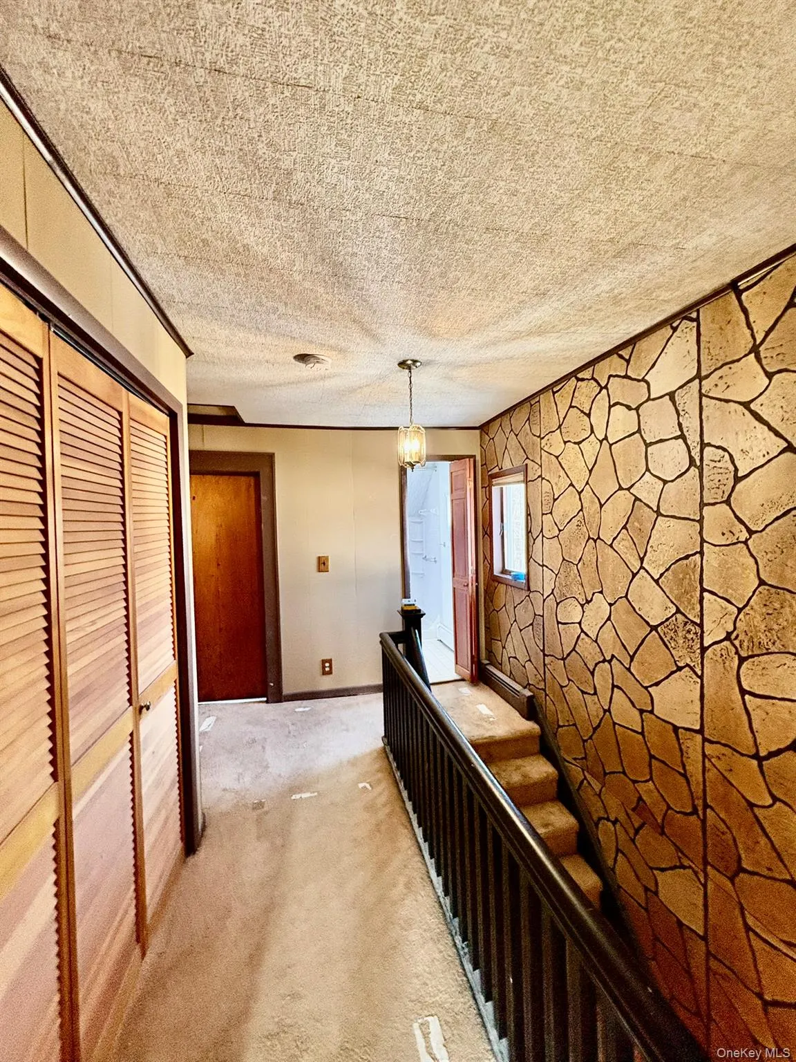 Hall with carpet flooring and a textured ceiling Hall with carpet flooring and a textured ceiling
