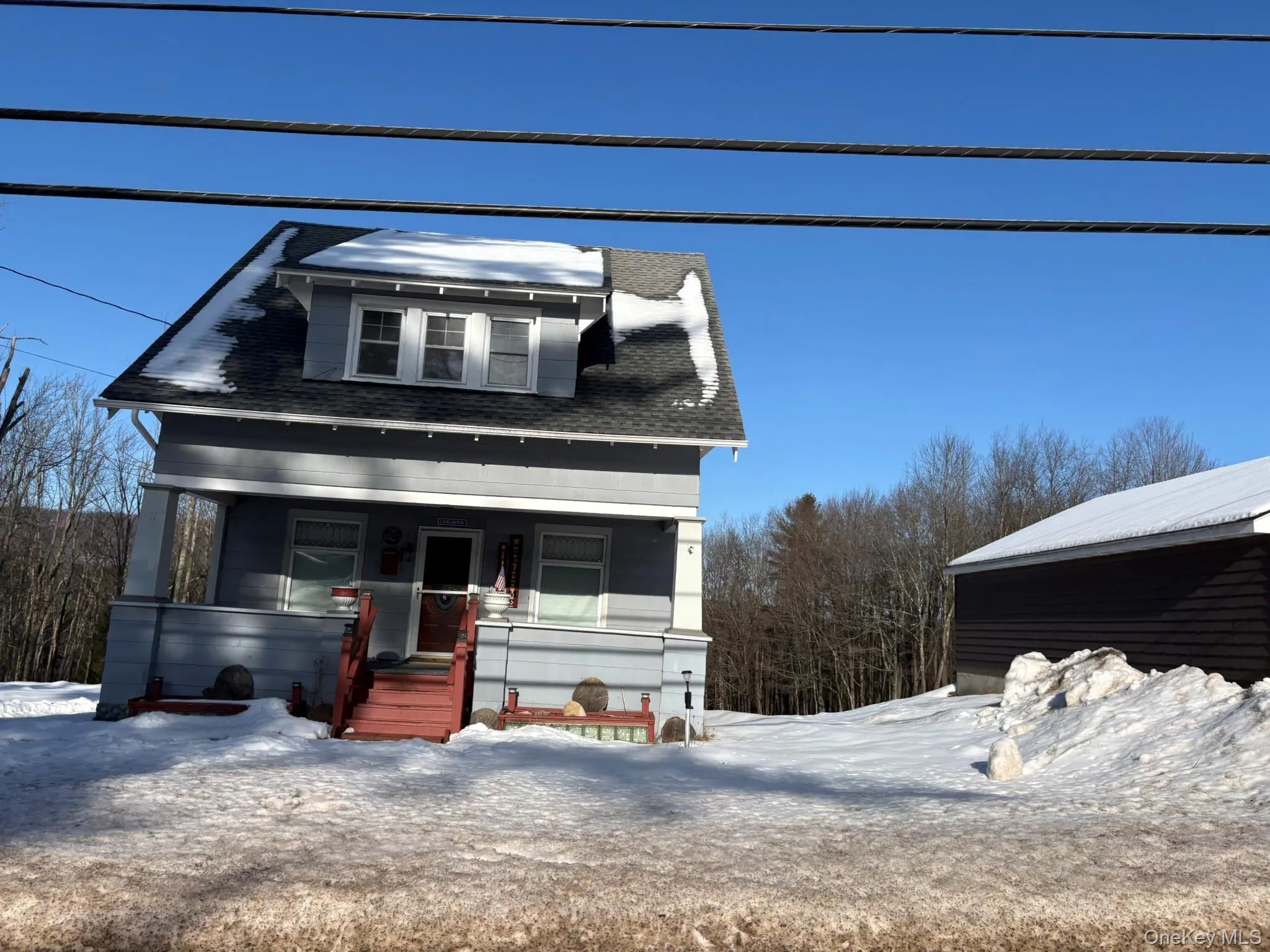 View of front of property featuring covered porch and a shingled roof View of front of property featuring covered porch and a shingled roof