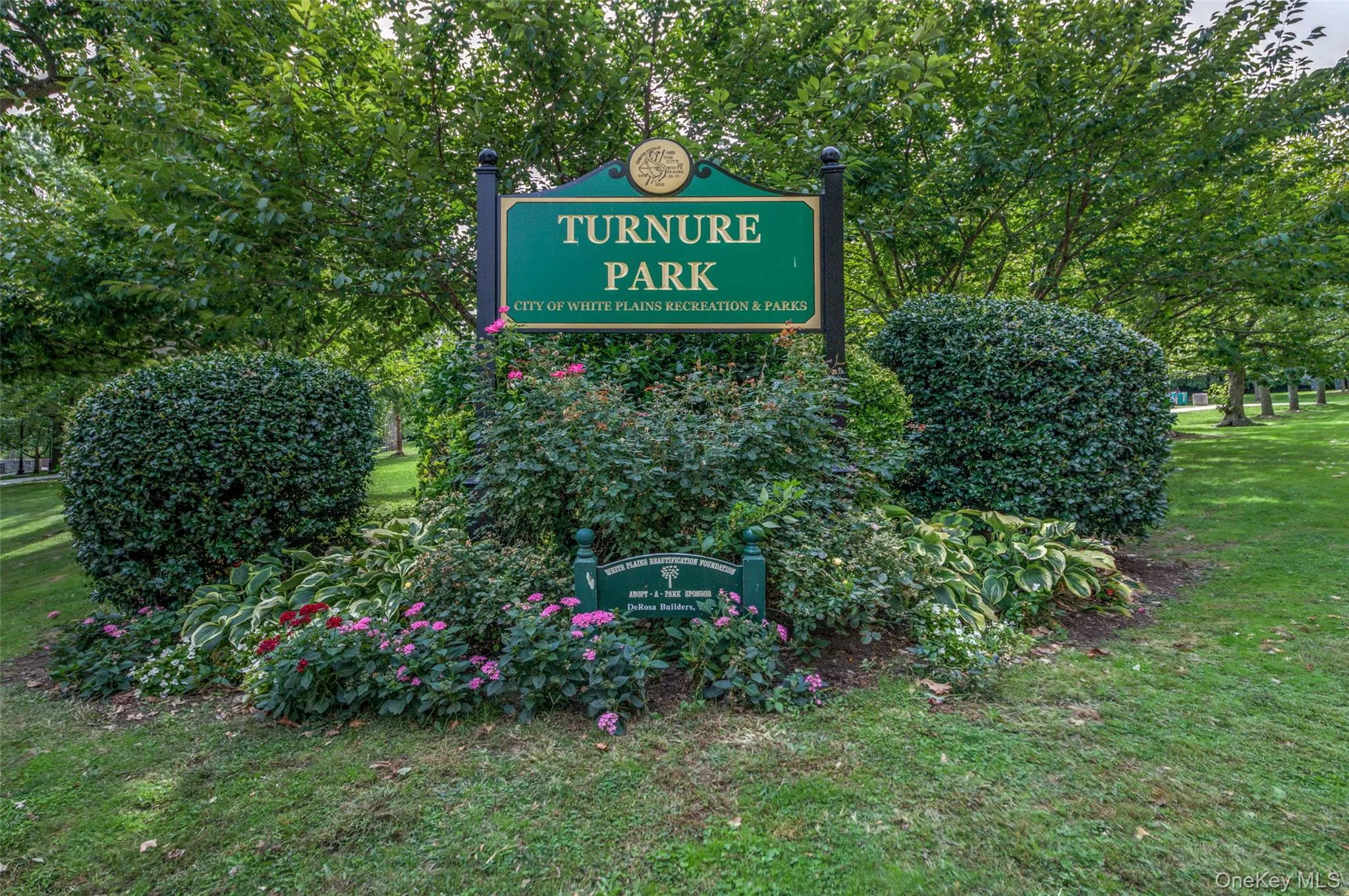 Community sign featuring a yard Community sign featuring a yard