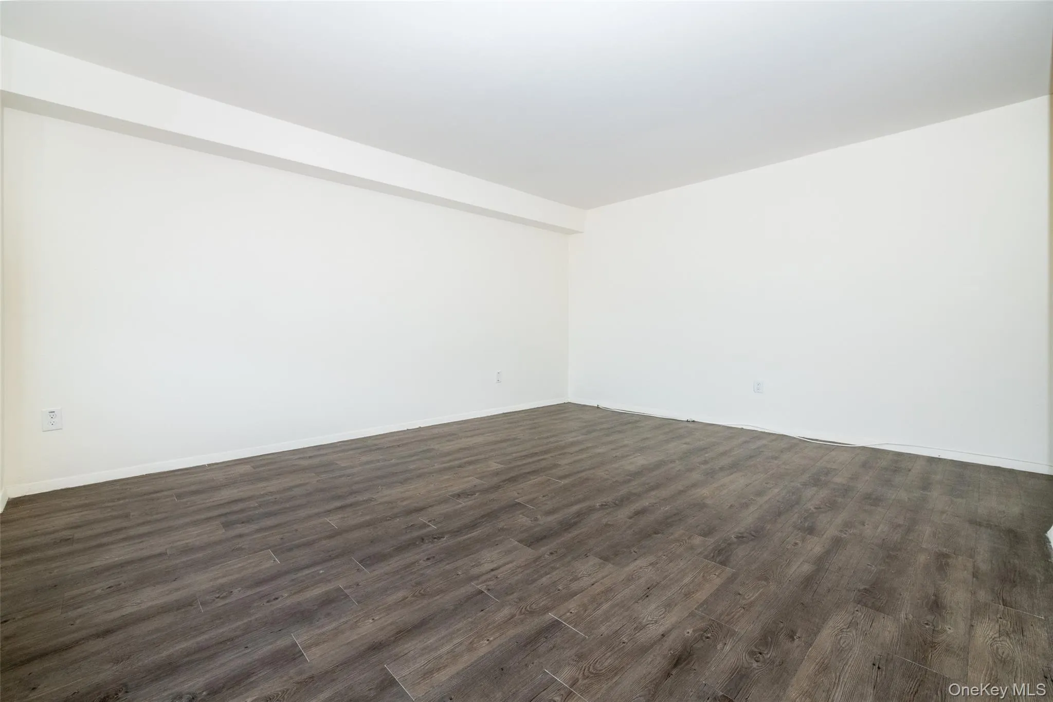 Spare room featuring dark wood finished floors and baseboards Spare room featuring dark wood finished floors and baseboards