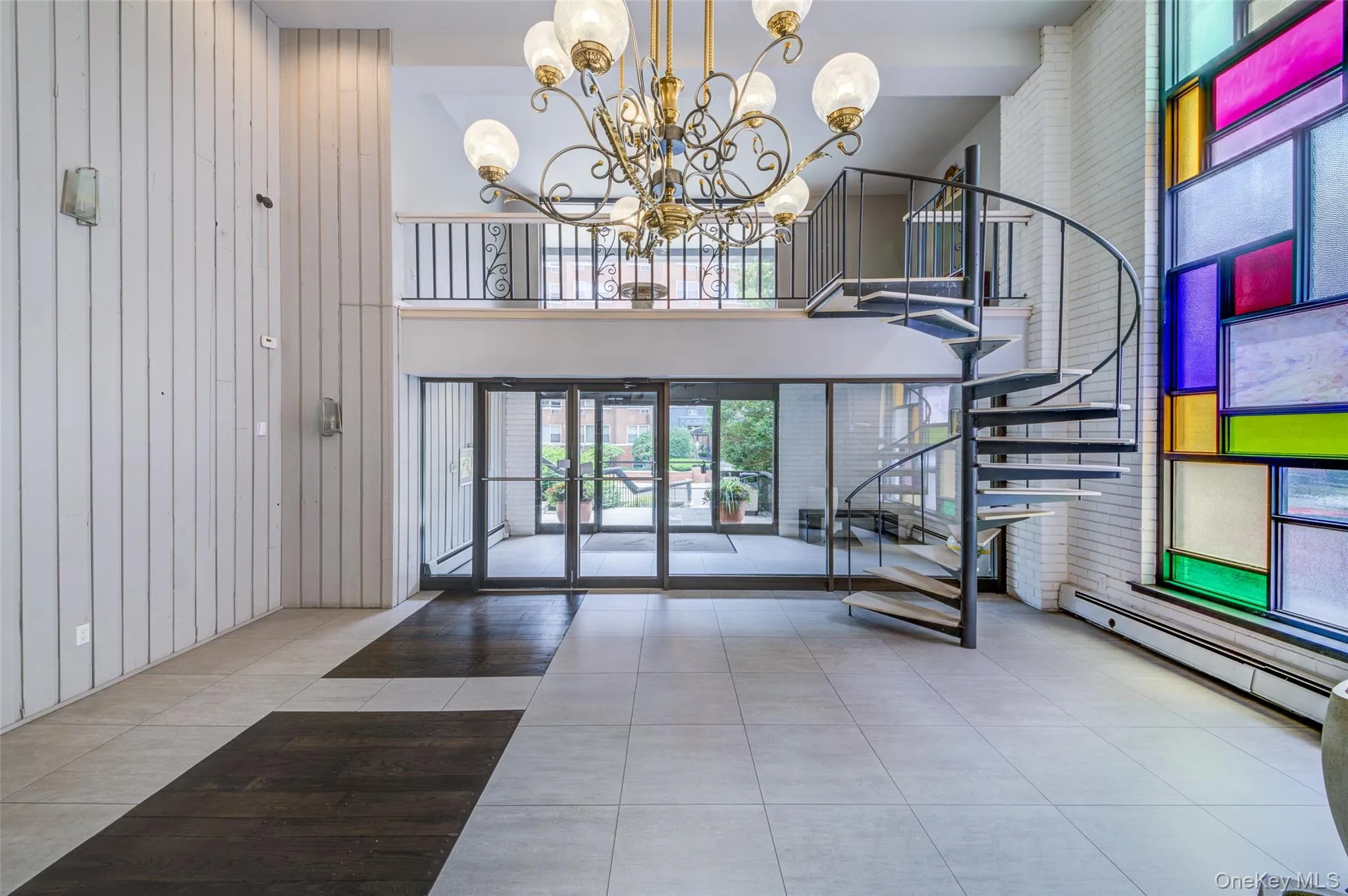 Lobby featuring stairs, wooden walls, and a high ceiling Lobby featuring stairs, wooden walls, and a high ceiling