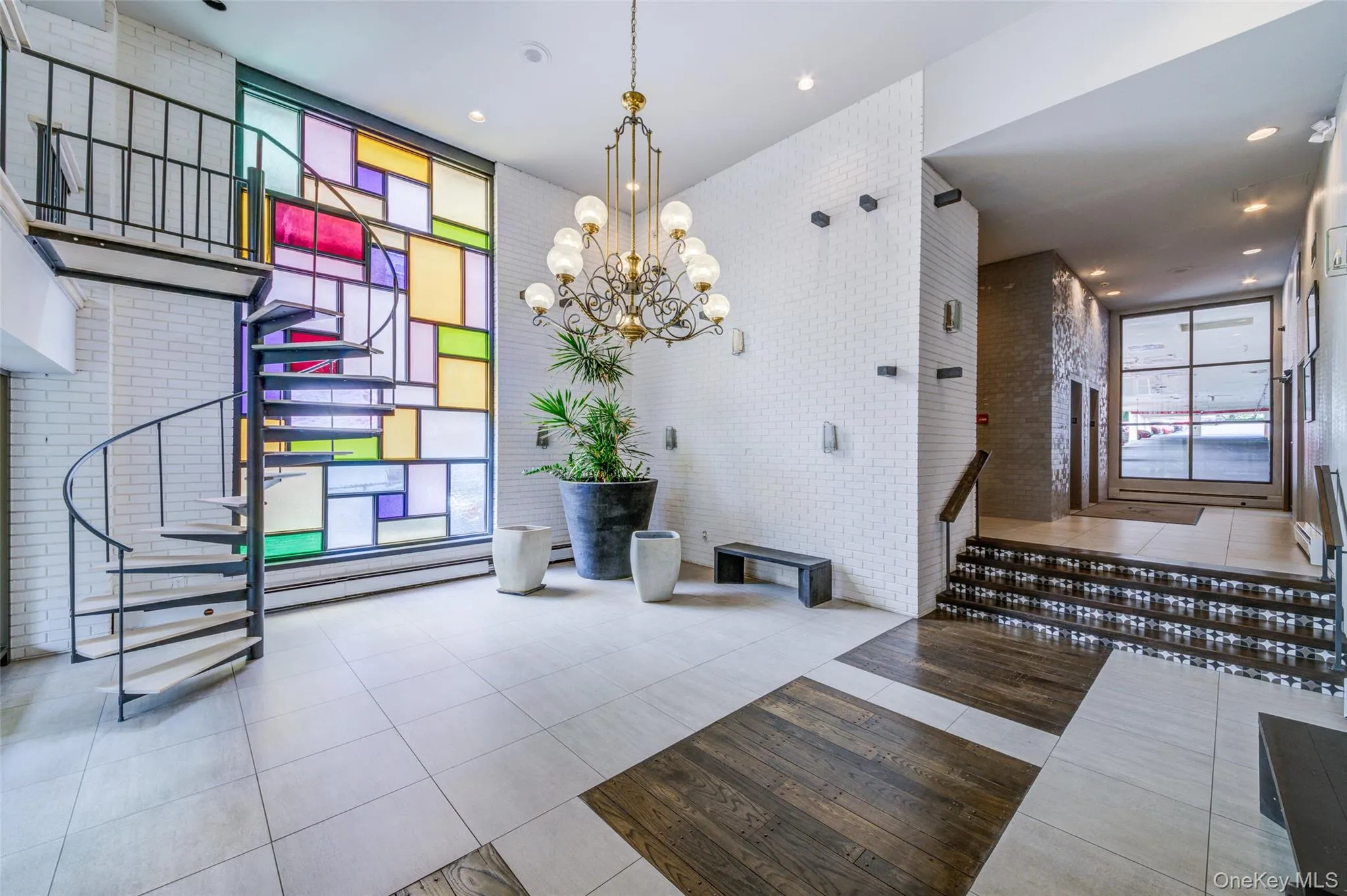Building lobby featuring stairs, a towering ceiling, and brick wall Building lobby featuring stairs, a towering ceiling, and brick wall