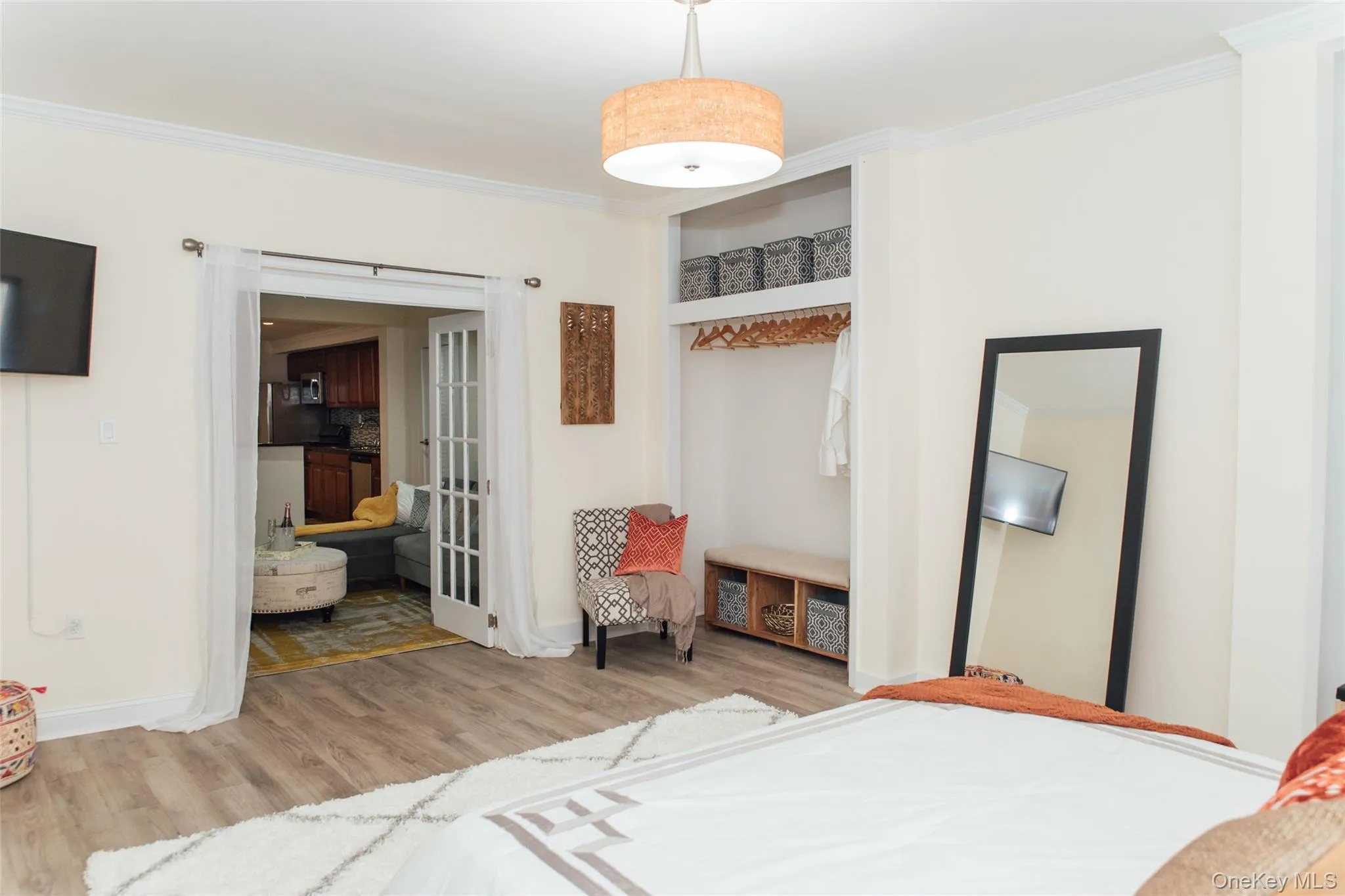 Bedroom with ornamental molding, light wood-style floors, and a closet Bedroom with ornamental molding, light wood-style floors, and a closet