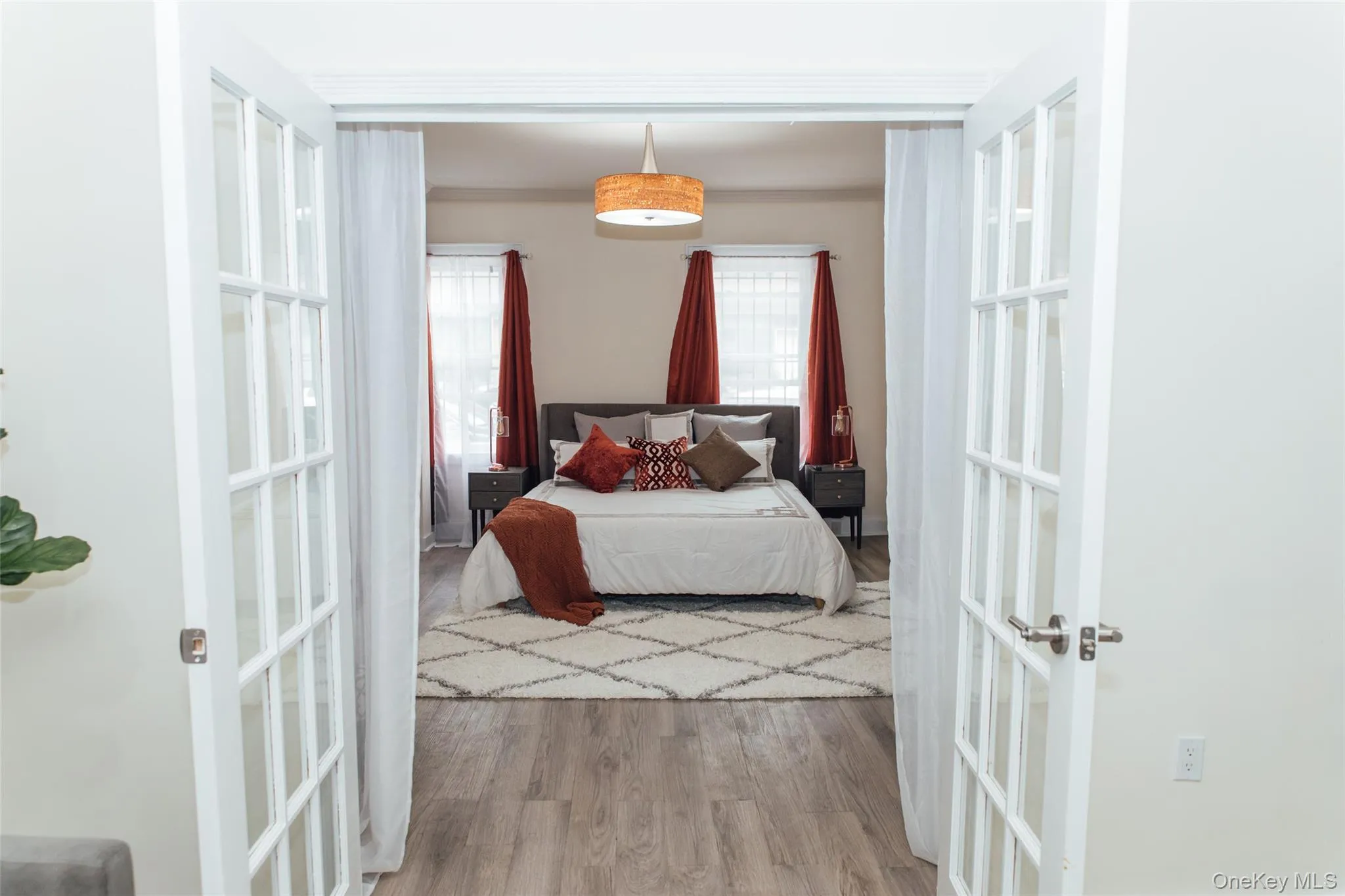 Bedroom featuring french doors and wood finished floors Bedroom featuring french doors and wood finished floors