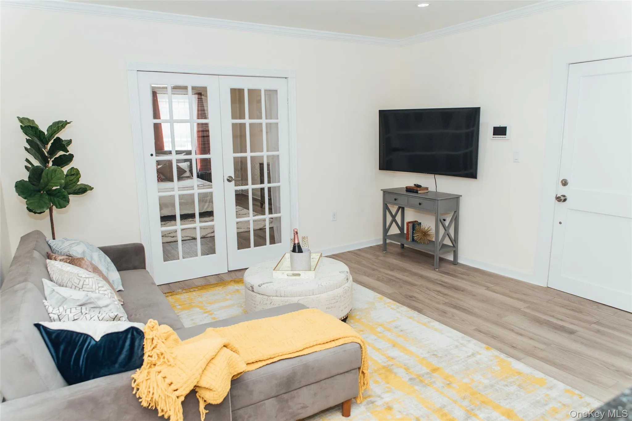 Living room with french doors, light wood-type flooring, and crown molding Living room with french doors, light wood-type flooring, and crown molding