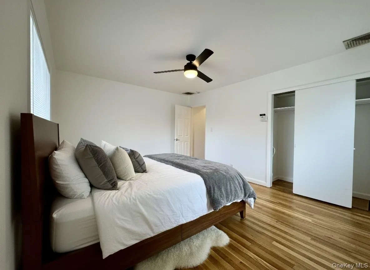 Bedroom featuring light wood-style floors, ceiling fan, and a closet Bedroom featuring light wood-style floors, ceiling fan, and a closet