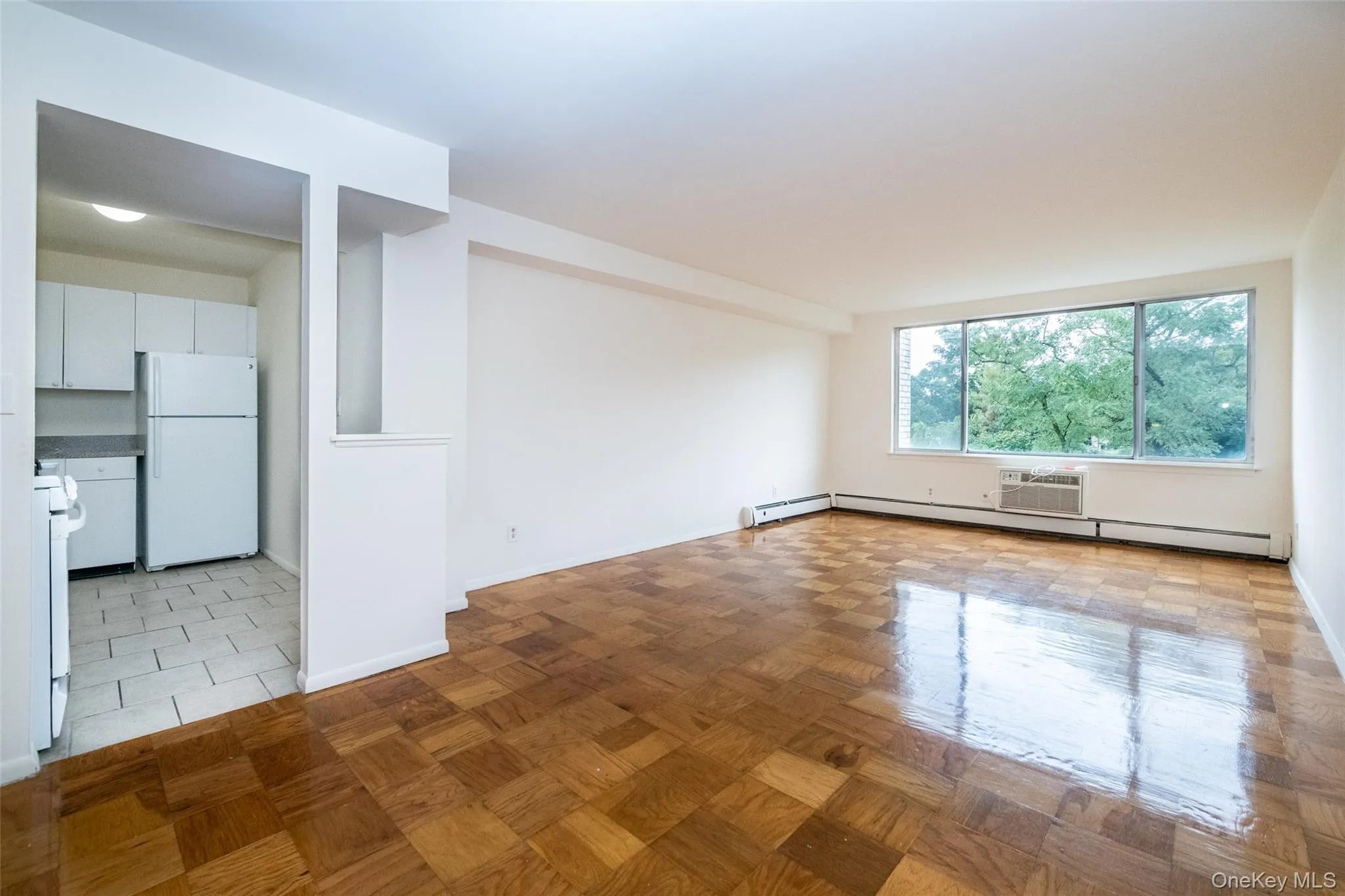 Empty room with a wall mounted air conditioner and a baseboard heating unit Empty room with a wall mounted air conditioner and a baseboard heating unit