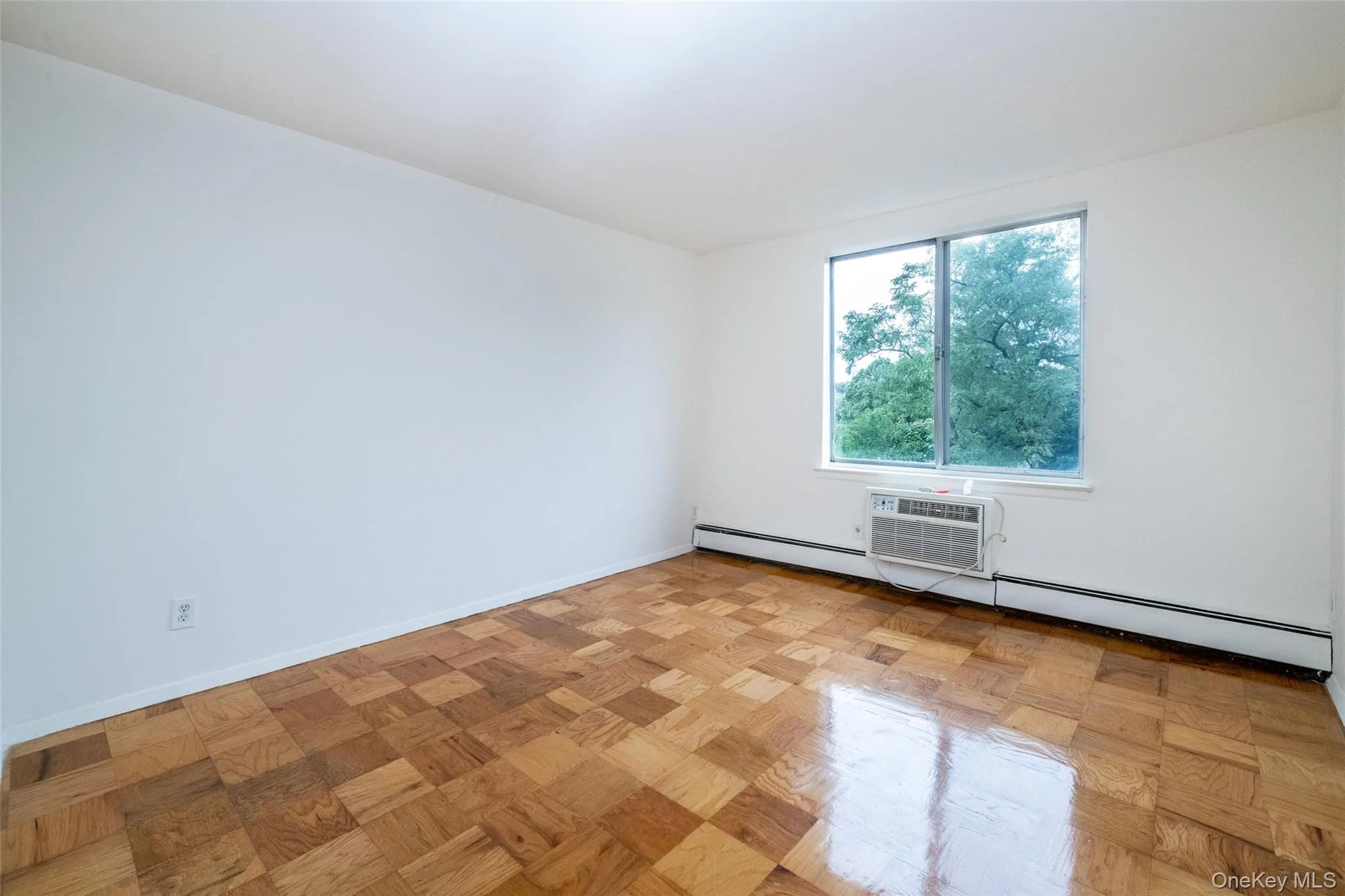 Spare room with a baseboard heating unit and a wall unit AC Spare room with a baseboard heating unit and a wall unit AC