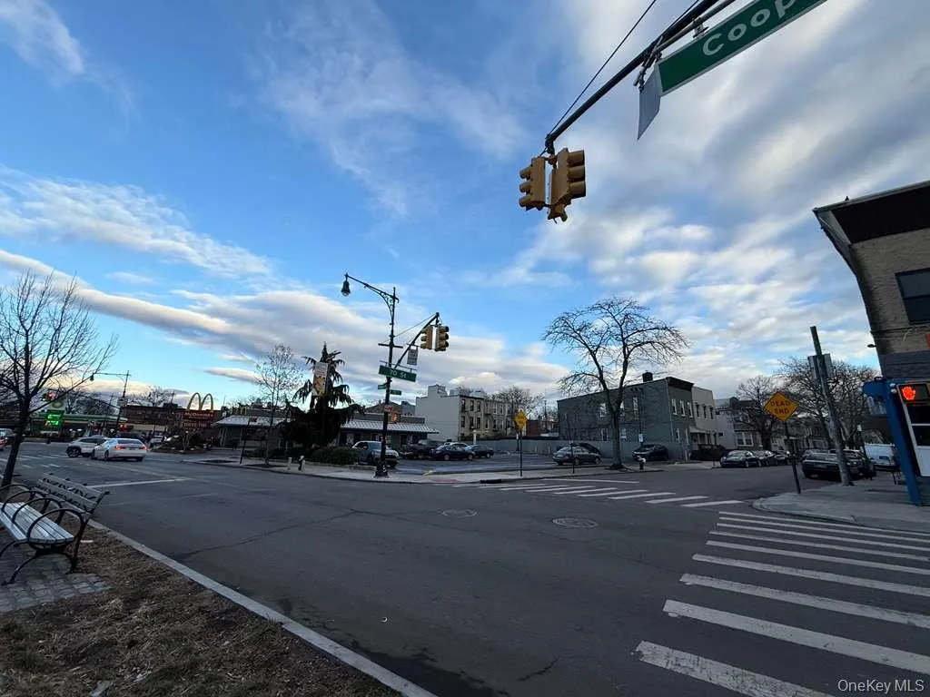 View of asphalt street with traffic lights, traffic signs, sidewalks, curbs, and street lights View of asphalt street with traffic lights, traffic signs, sidewalks, curbs, and street lights