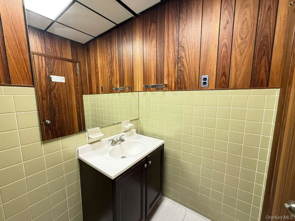 Bathroom featuring vanity and tile walls Bathroom featuring vanity and tile walls