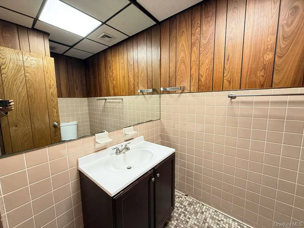 Bathroom featuring vanity and tile walls Bathroom featuring vanity and tile walls