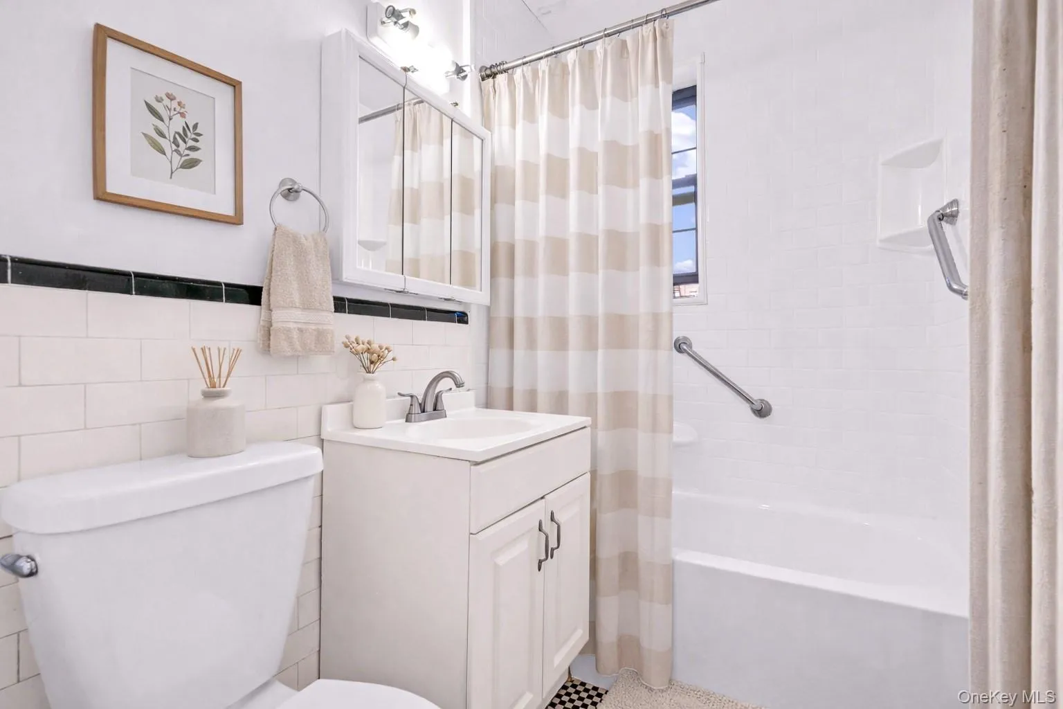 Bathroom with tile walls, vanity, shower / tub combo, and tasteful backsplash Bathroom with tile walls, vanity, shower / tub combo, and tasteful backsplash