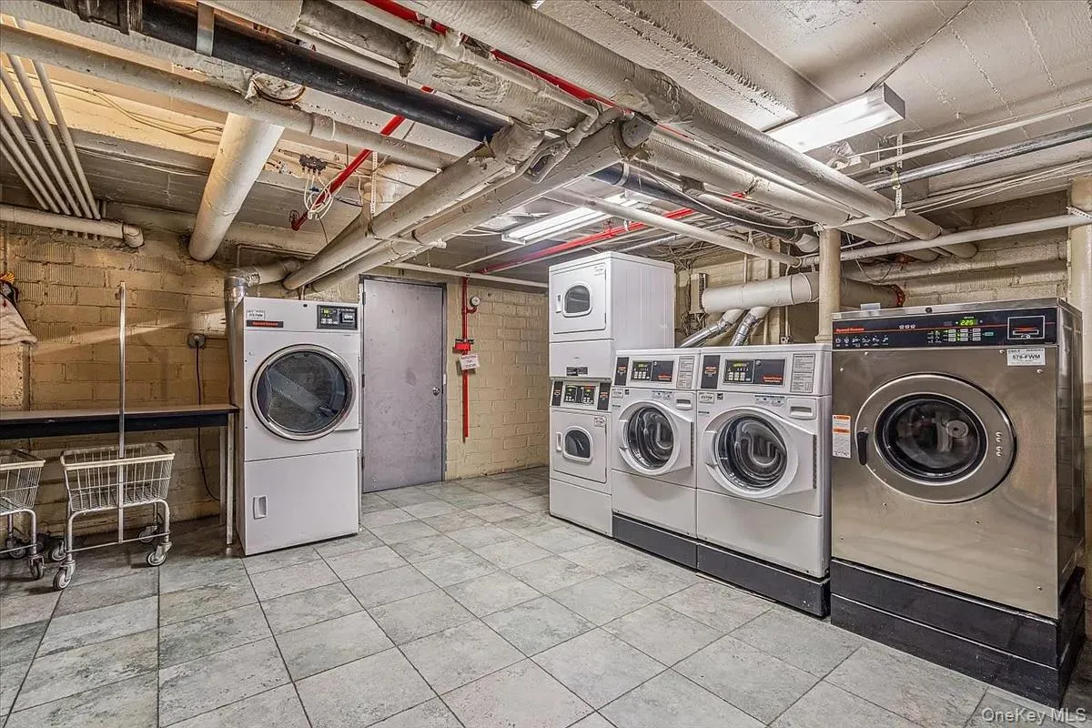 Shared laundry featuring washing machine and dryer and estacked washer and dryer Shared laundry featuring washing machine and dryer and estacked washer and dryer