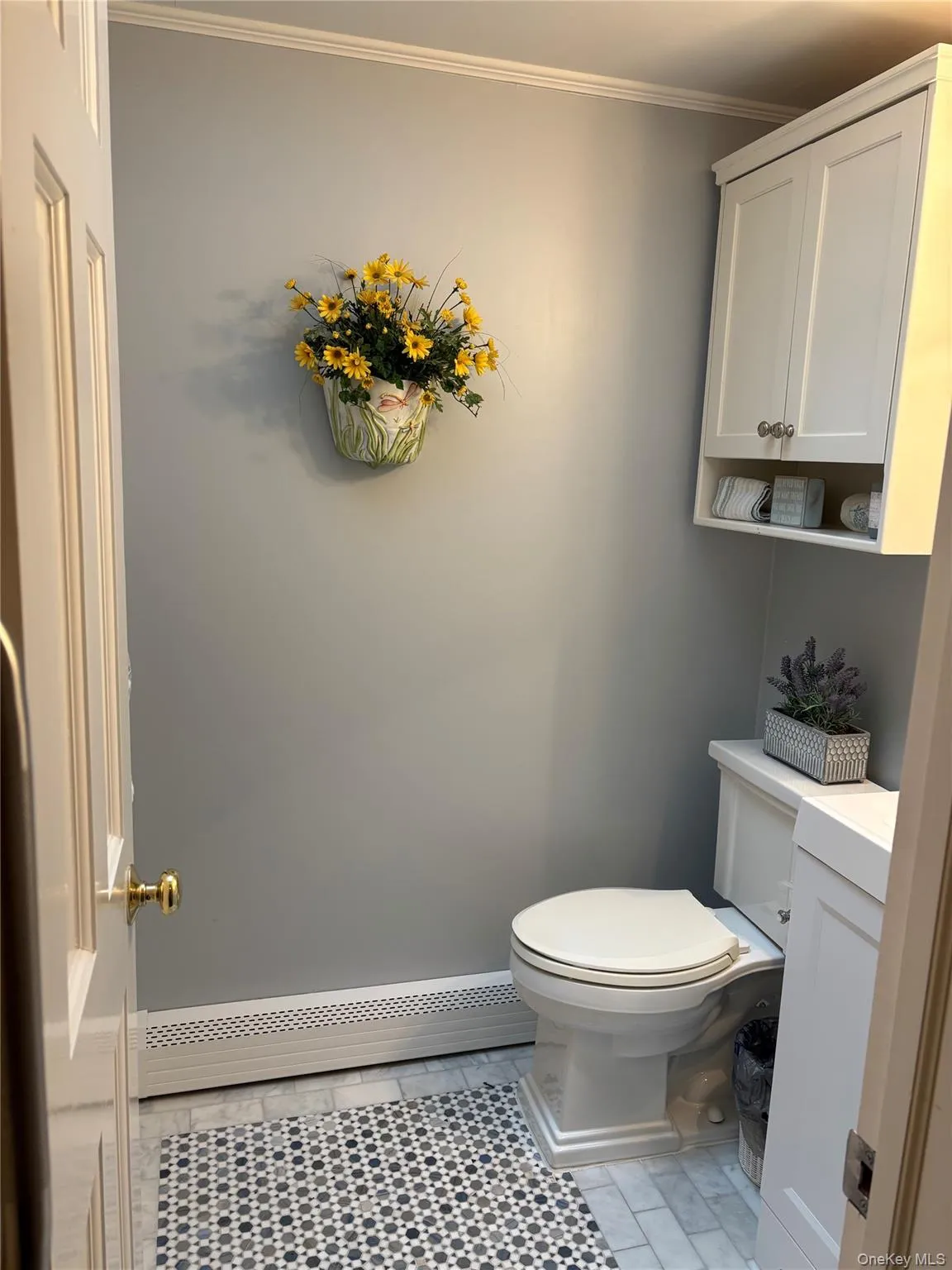 Lower level powder room next to kitchen, vanity, and ornamental molding Lower level powder room next to kitchen, vanity, and ornamental molding