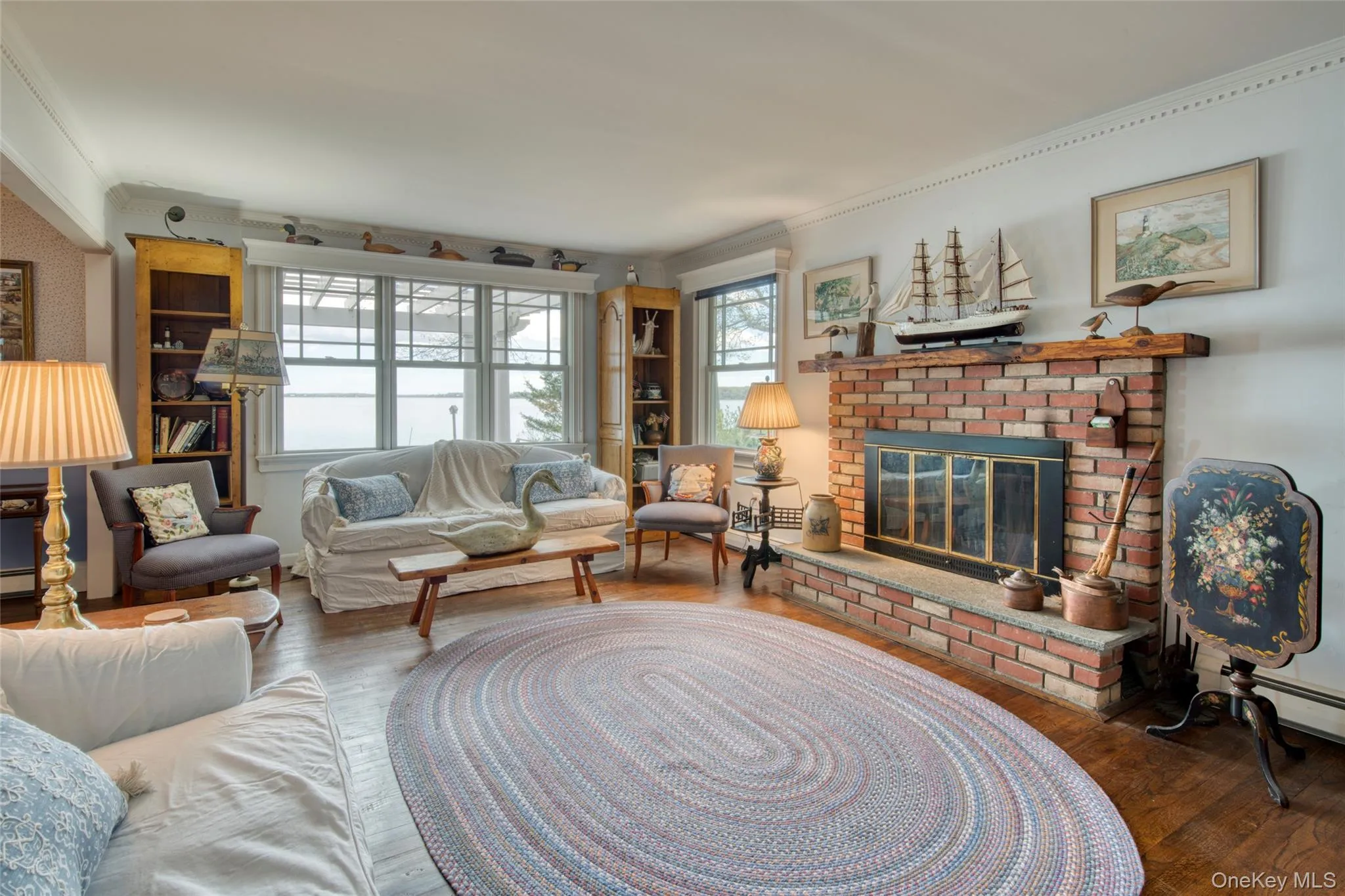 Living room with wood finished floors, a fireplace, and ornamental molding Living room with wood finished floors, a fireplace, and ornamental molding