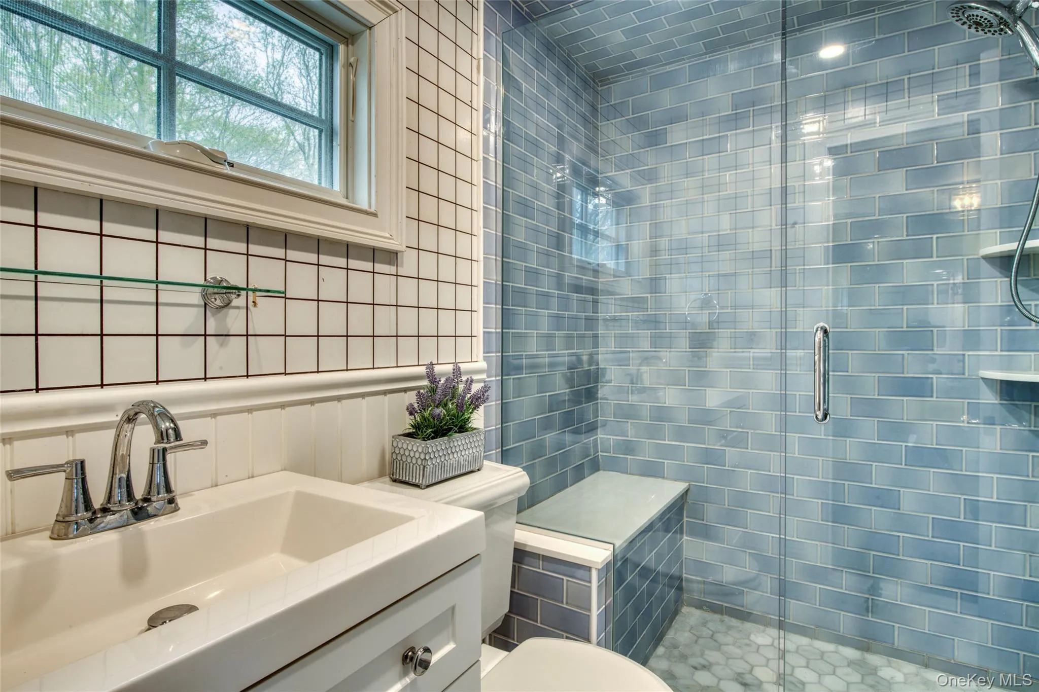 Full bathroom with a stall shower, vanity, and tile walls, built in shower chair Full bathroom with a stall shower, vanity, and tile walls, built in shower chair