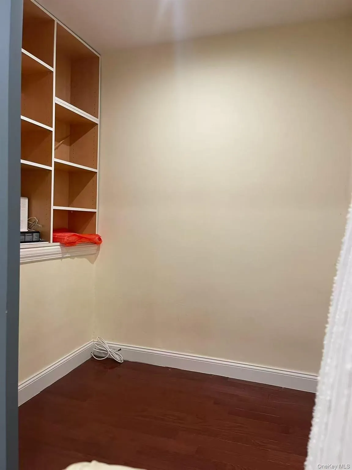 Unfurnished room featuring baseboards and dark wood-type flooring Unfurnished room featuring baseboards and dark wood-type flooring