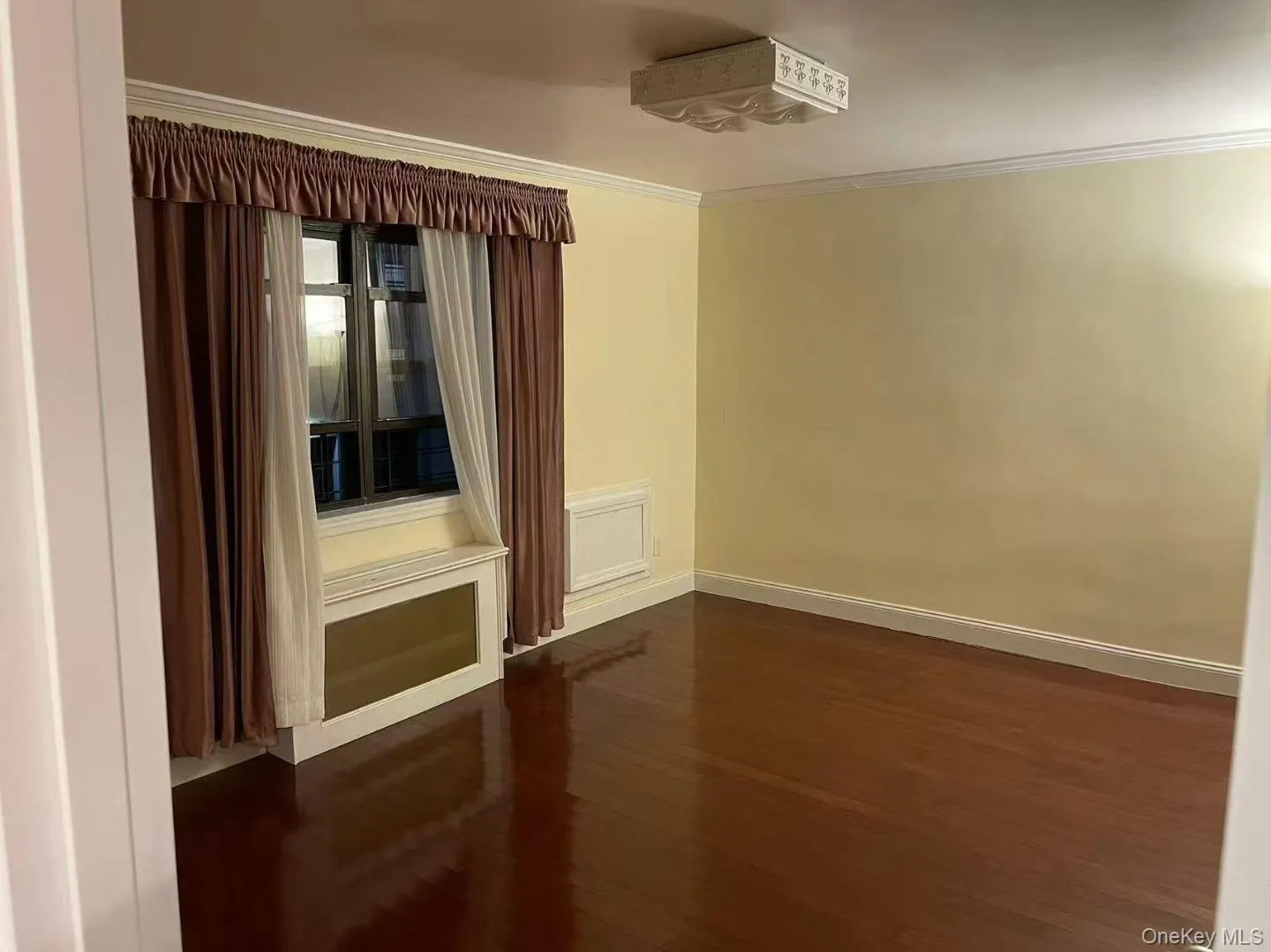 Empty room with dark wood-style flooring and crown molding Empty room with dark wood-style flooring and crown molding