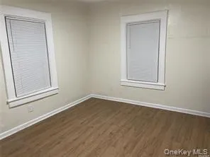 Unfurnished room with dark wood-type flooring and baseboards Unfurnished room with dark wood-type flooring and baseboards