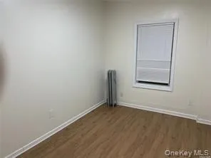 Spare room featuring dark wood-style flooring and baseboards Spare room featuring dark wood-style flooring and baseboards
