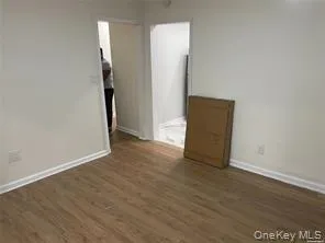 Empty room with dark wood-type flooring and baseboards Empty room with dark wood-type flooring and baseboards