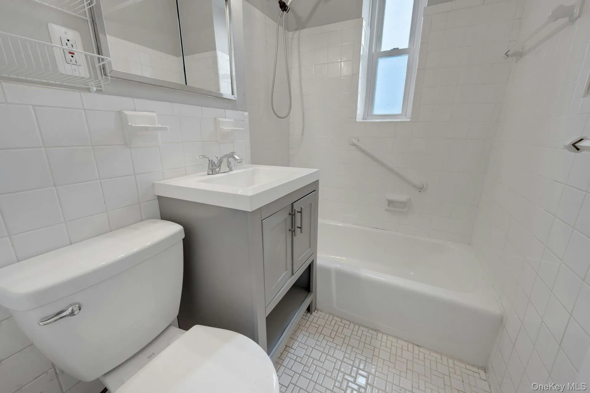 Full bathroom featuring vanity, tile walls, and shower / tub combination Full bathroom featuring vanity, tile walls, and shower / tub combination
