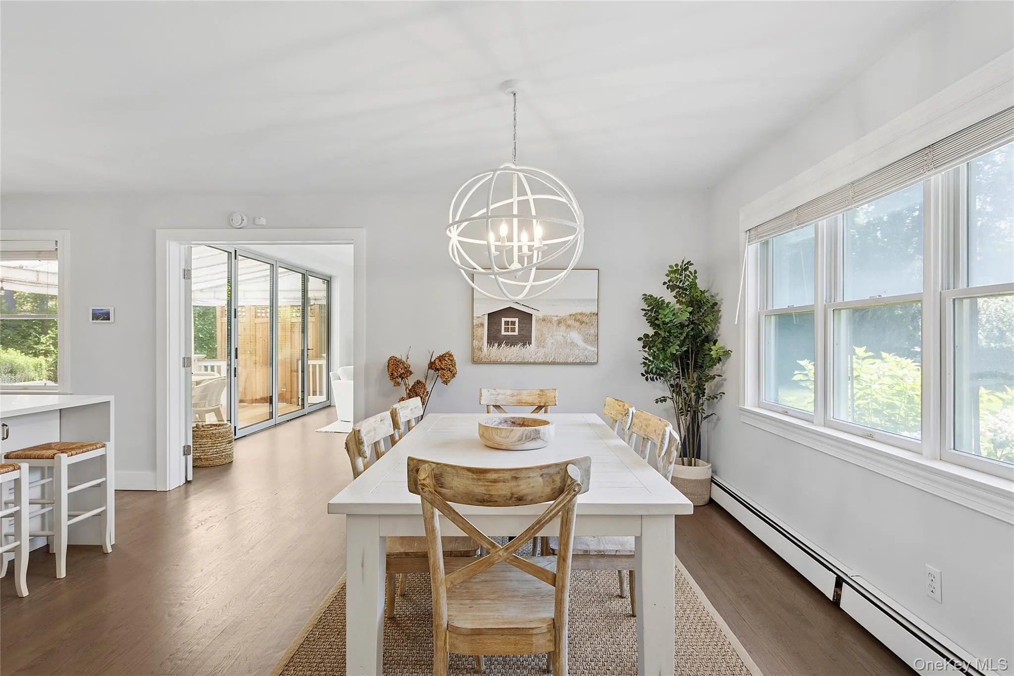 Dining space featuring a baseboard heating unit, plenty of natural light, and dark wood-style floors Dining space featuring a baseboard heating unit, plenty of natural light, and dark wood-style floors