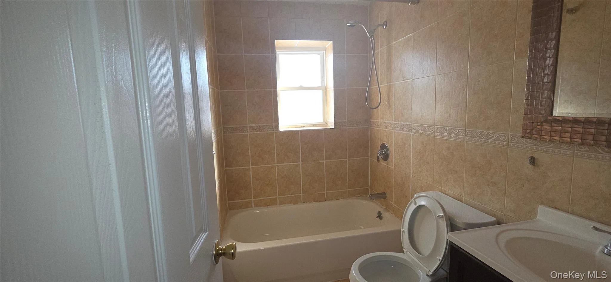 Bathroom with vanity, tile walls, and tub / shower combination Bathroom with vanity, tile walls, and tub / shower combination