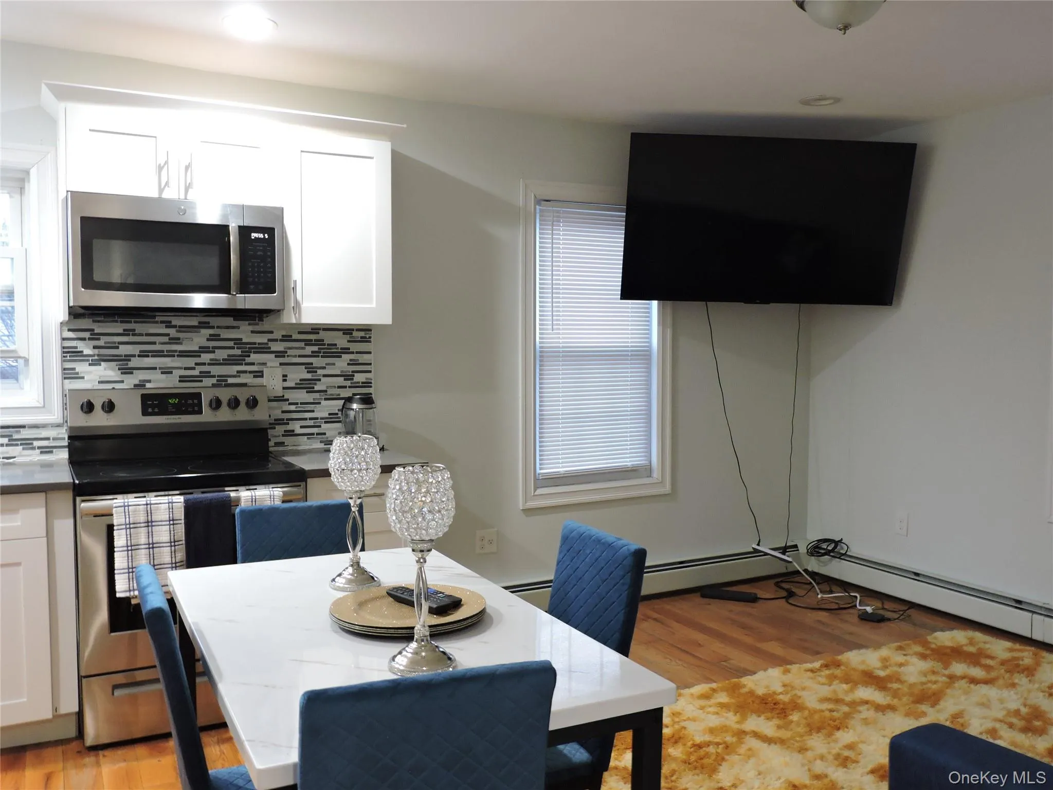 Dining space with light wood-style flooring, plenty of natural light, baseboard heating, and a baseboard heating unit Dining space with light wood-style flooring, plenty of natural light, baseboard heating, and a baseboard heating unit