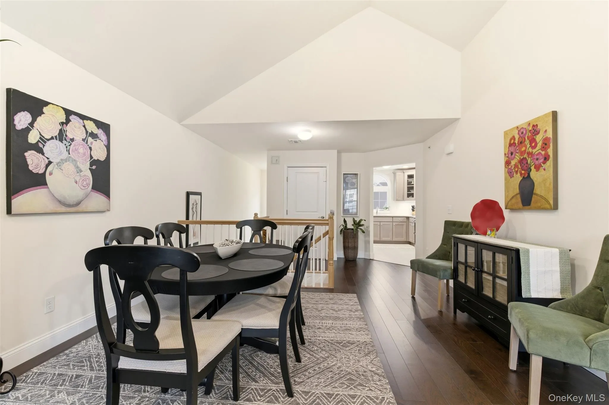 Dining room featuring dark wood-style flooring and high vaulted ceiling Dining room featuring dark wood-style flooring and high vaulted ceiling
