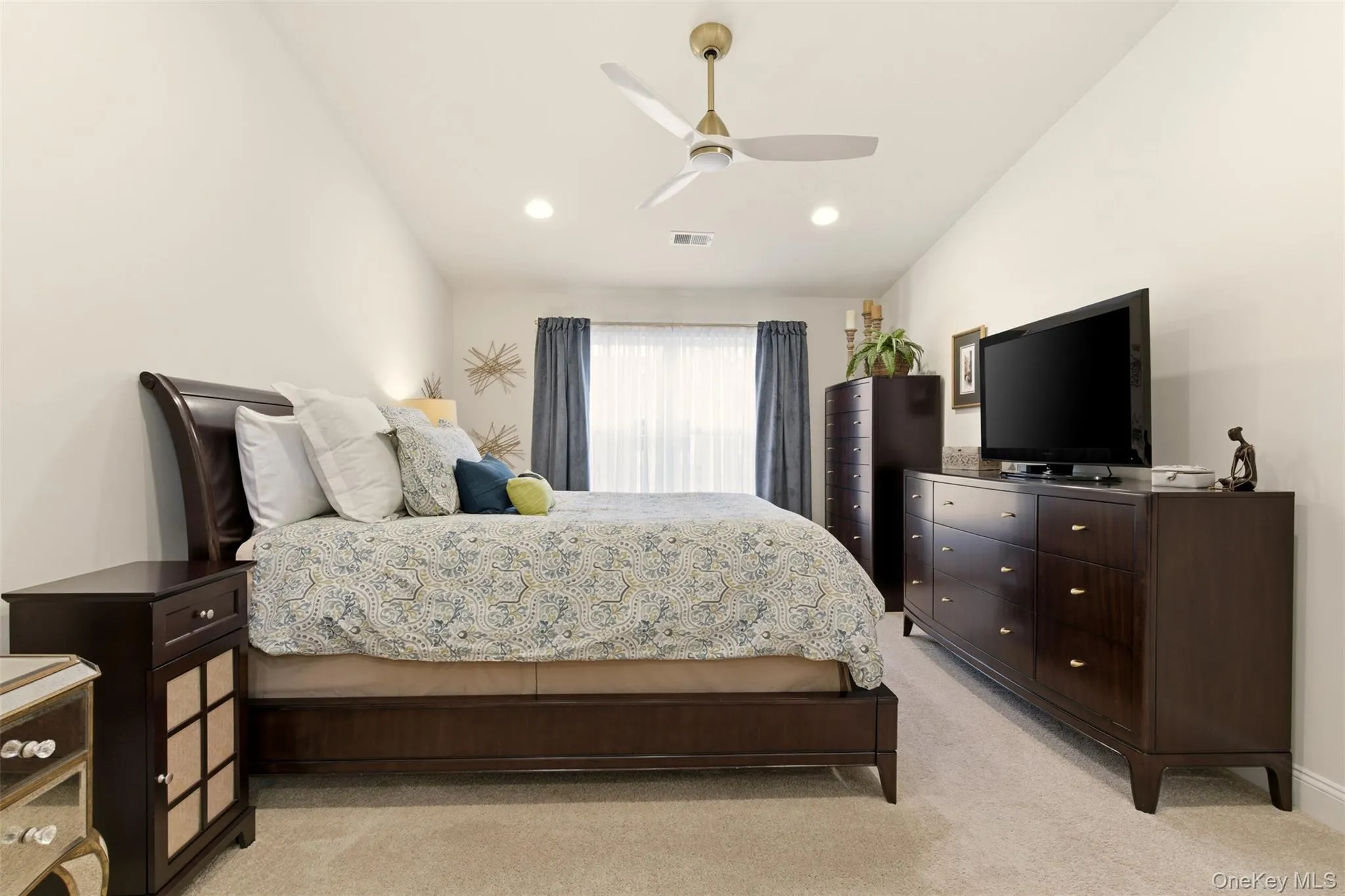 Bedroom featuring light colored carpet, vaulted ceiling, and ceiling fan Bedroom featuring light colored carpet, vaulted ceiling, and ceiling fan