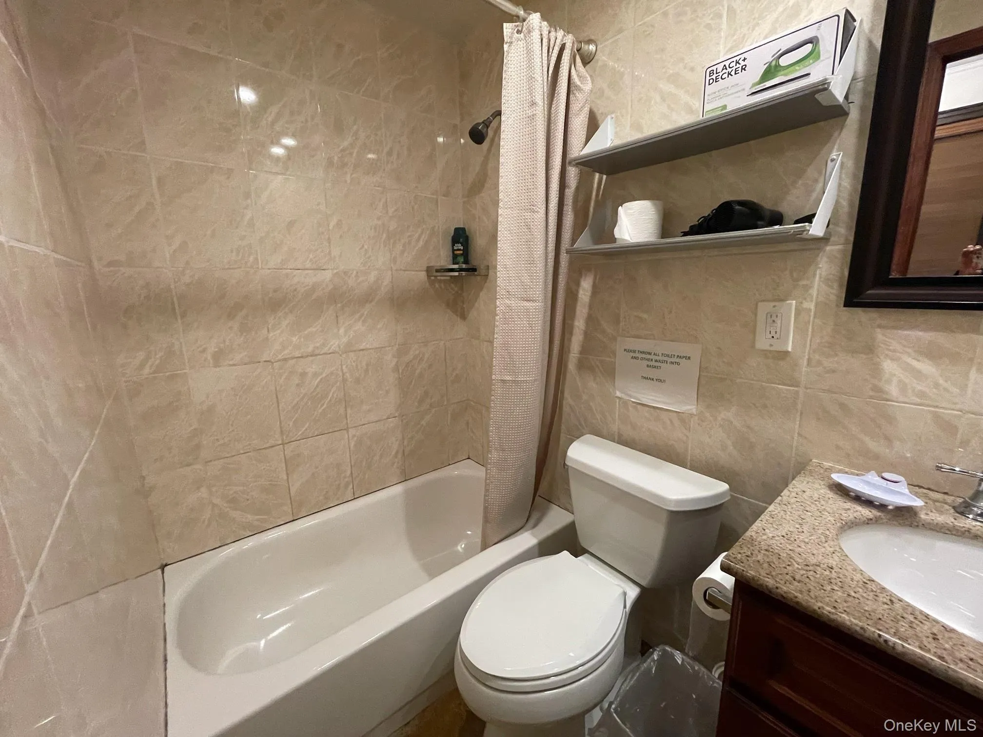 Bathroom featuring shower / tub combo with curtain, tile walls, and vanity Bathroom featuring shower / tub combo with curtain, tile walls, and vanity