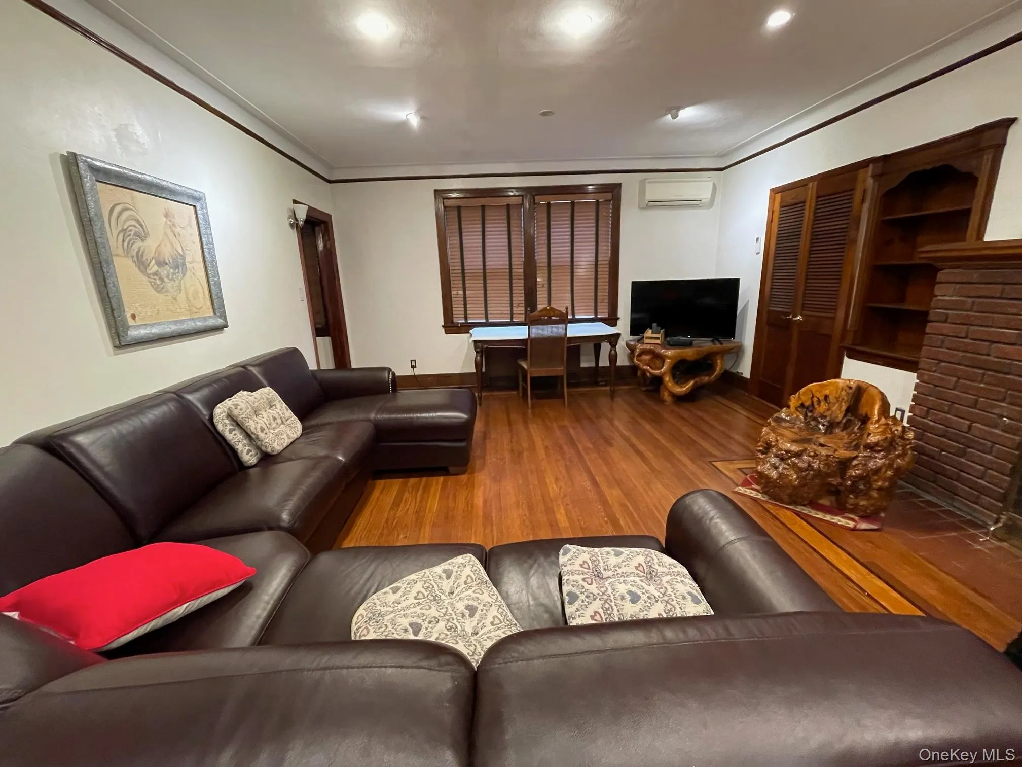 Living room with wood finished floors, ornamental molding, an AC wall unit, and recessed lighting Living room with wood finished floors, ornamental molding, an AC wall unit, and recessed lighting