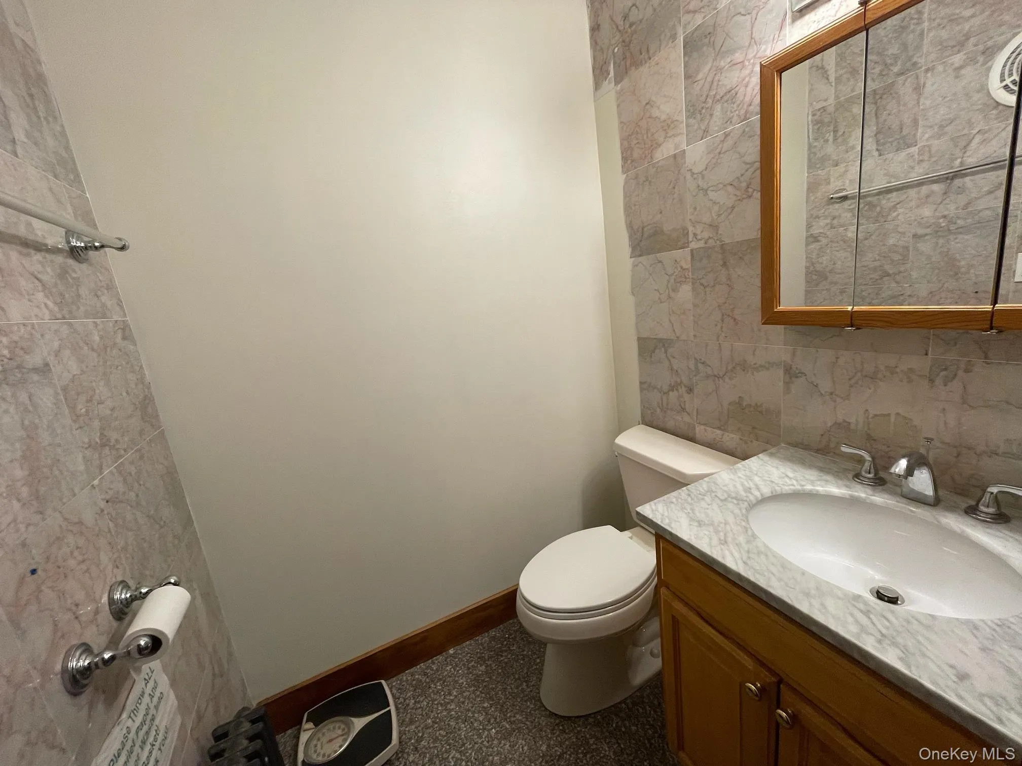 Half bath featuring vanity, tile walls, and tasteful backsplash Half bath featuring vanity, tile walls, and tasteful backsplash