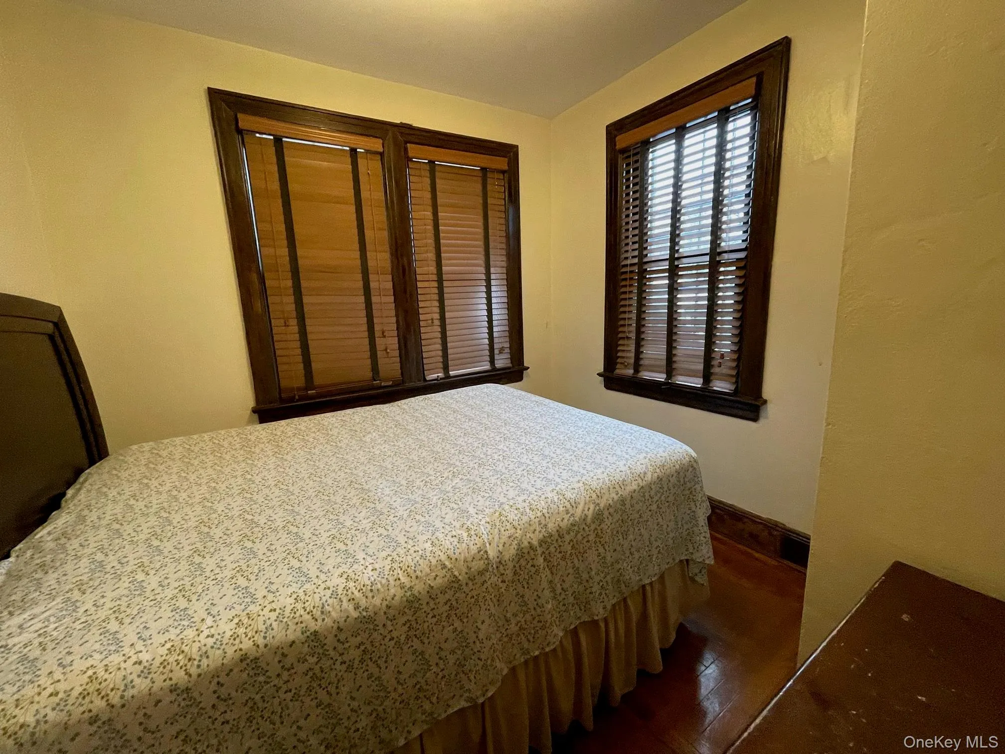 Bedroom featuring dark wood-type flooring and baseboards Bedroom featuring dark wood-type flooring and baseboards