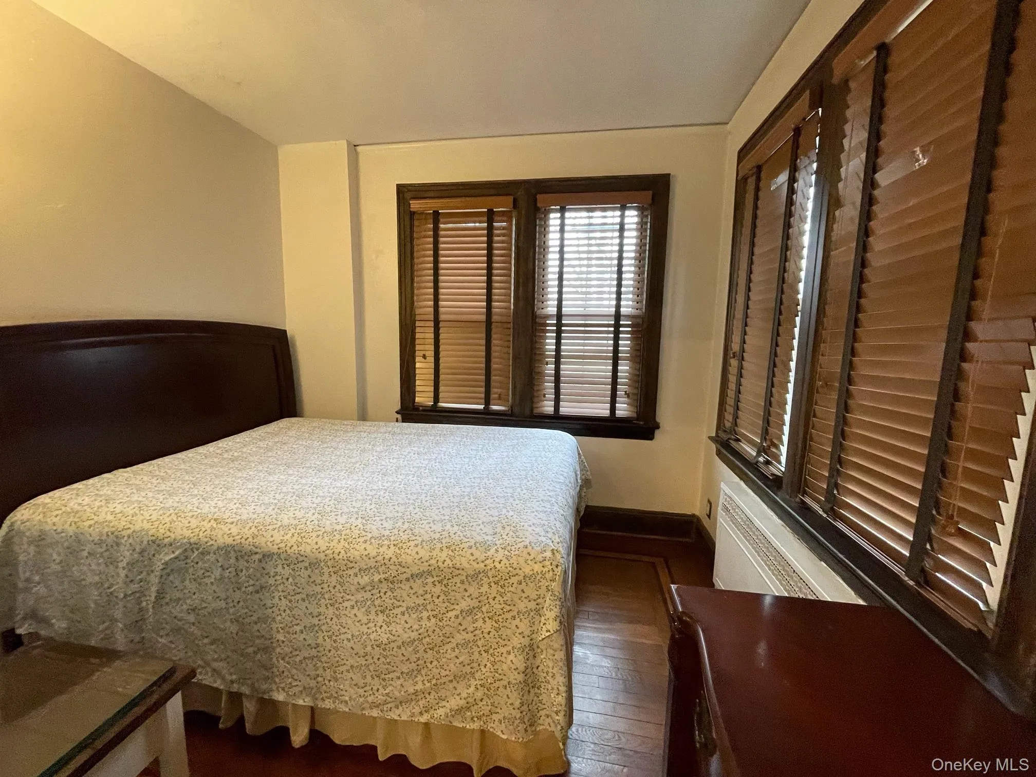 Bedroom featuring dark wood finished floors and baseboards Bedroom featuring dark wood finished floors and baseboards