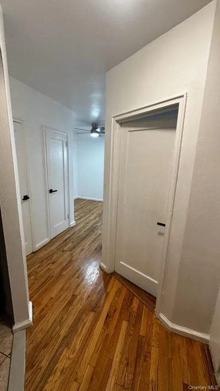 Hall with light wood-style flooring and baseboards Hall with light wood-style flooring and baseboards