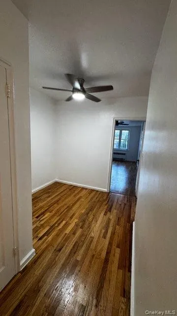 Unfurnished room featuring dark wood finished floors, ceiling fan, and a textured ceiling Unfurnished room featuring dark wood finished floors, ceiling fan, and a textured ceiling