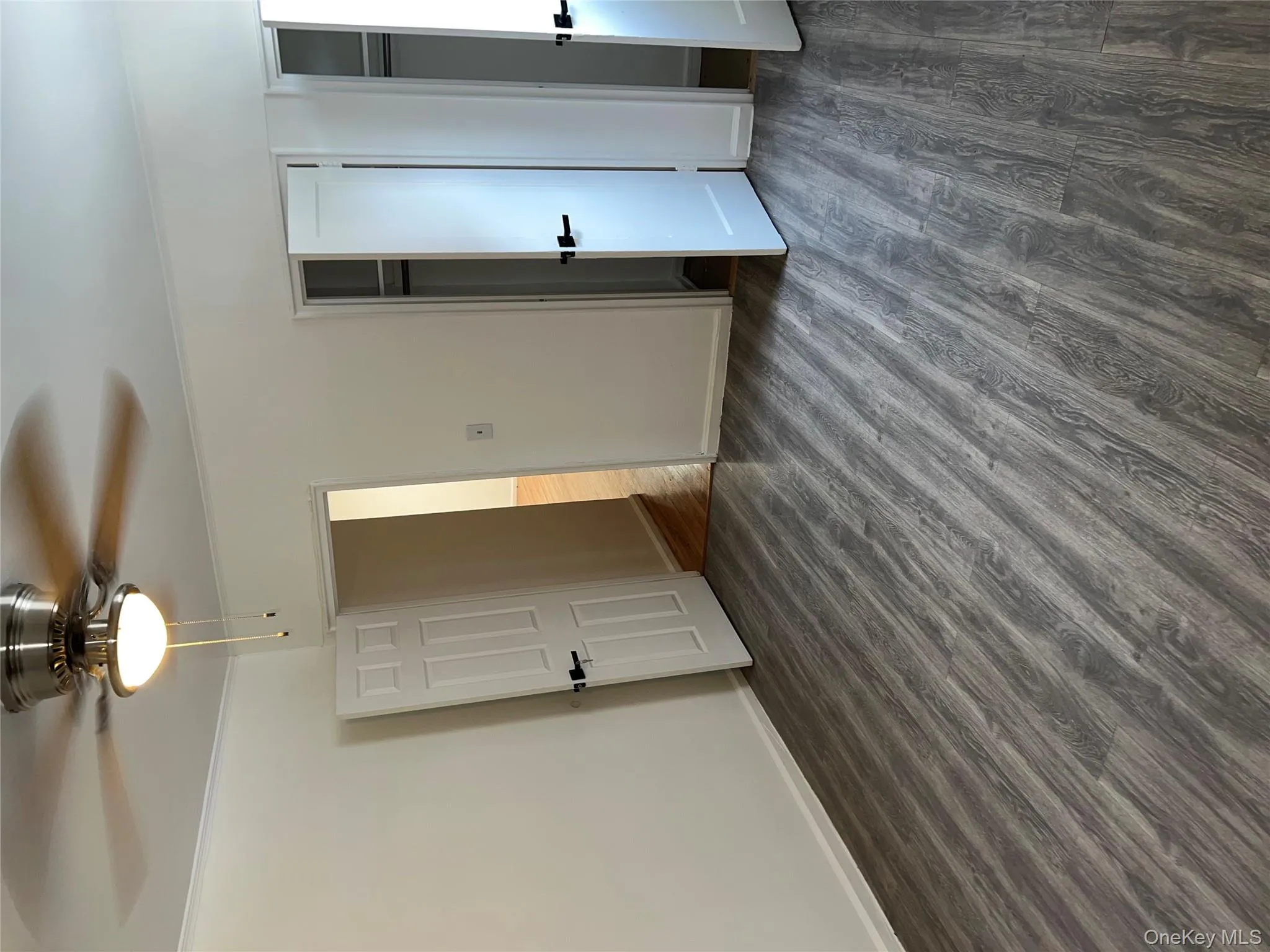 Unfurnished bedroom with dark wood-style flooring, a ceiling fan, two closets, and ornamental molding Unfurnished bedroom with dark wood-style flooring, a ceiling fan, two closets, and ornamental molding