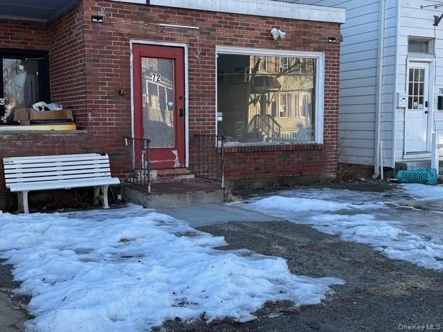 Storefront entrance with view of the front yard and brick siding... Storefront entrance with view of the front yard and brick siding...
