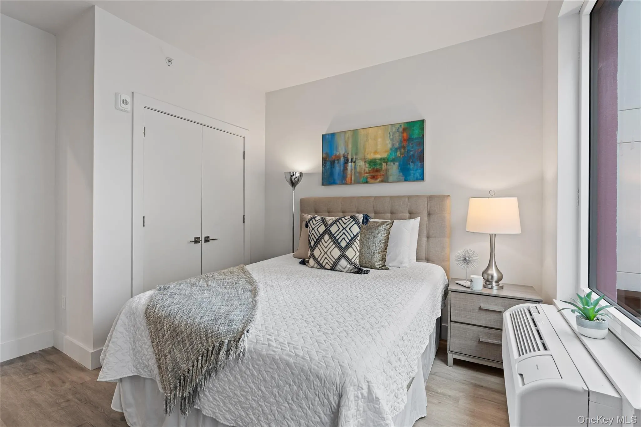 Bedroom featuring a closet, wood finished floors, and a wall unit AC Bedroom featuring a closet, wood finished floors, and a wall unit AC