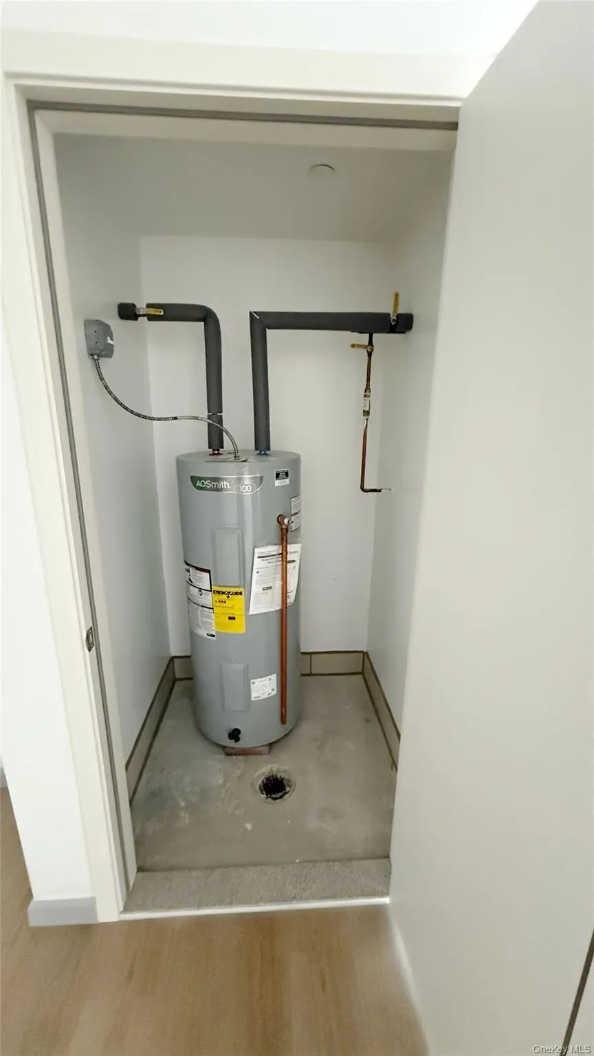 Utility room featuring electric water heater Utility room featuring electric water heater